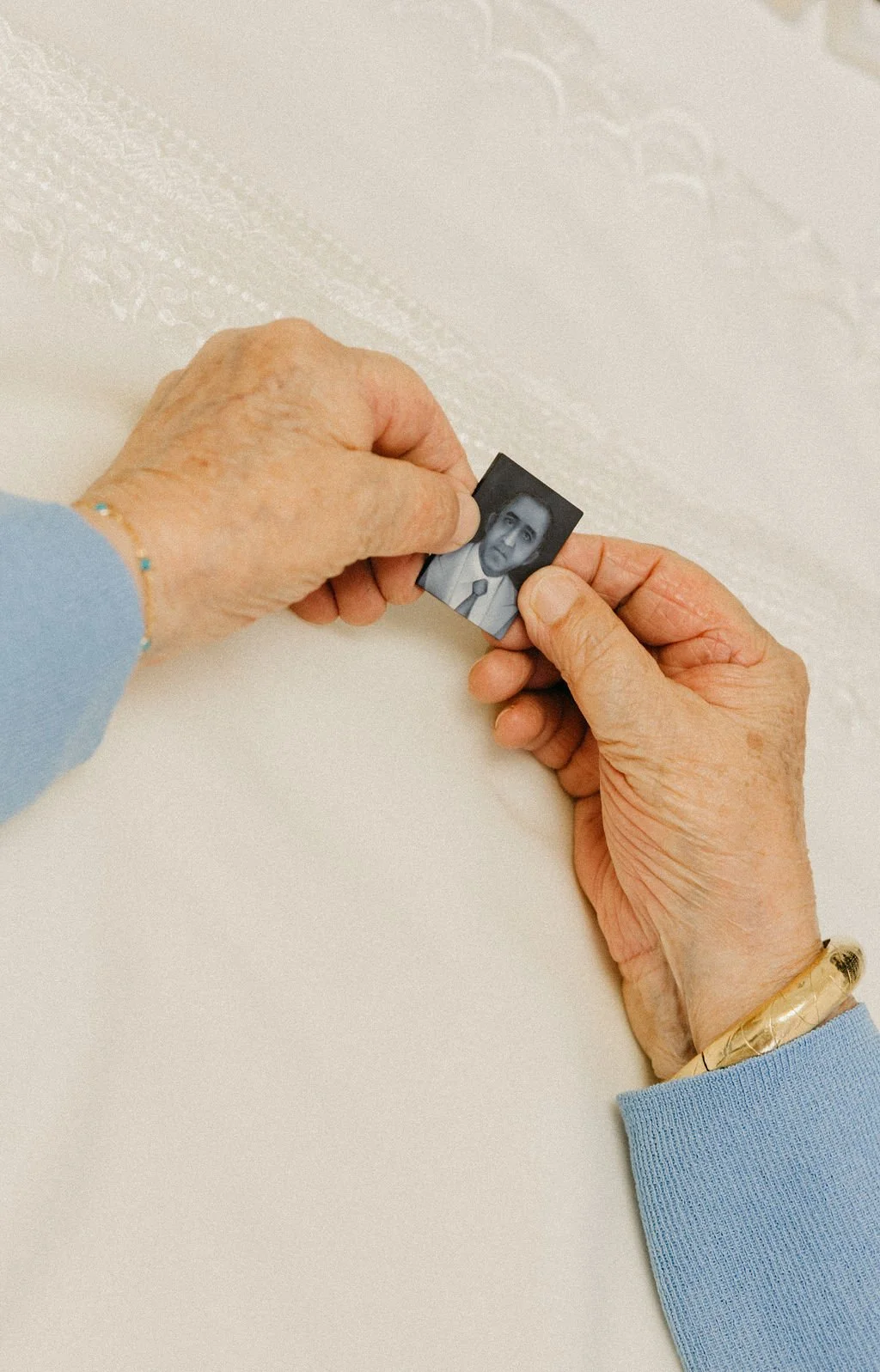 Hands holding a small vintage family photograph.