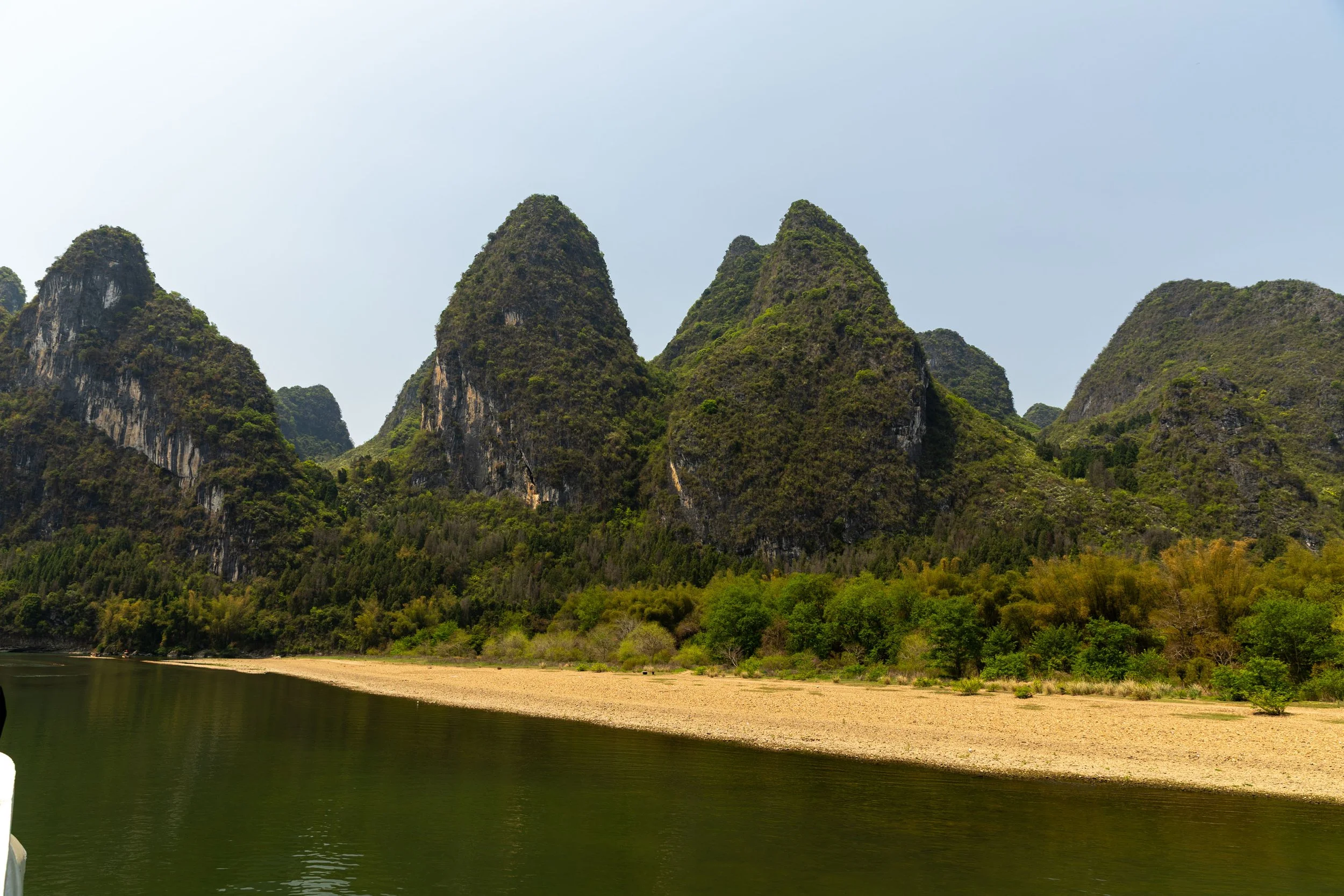 Karst mountains in Guilin, China, with a river and green vegetation.