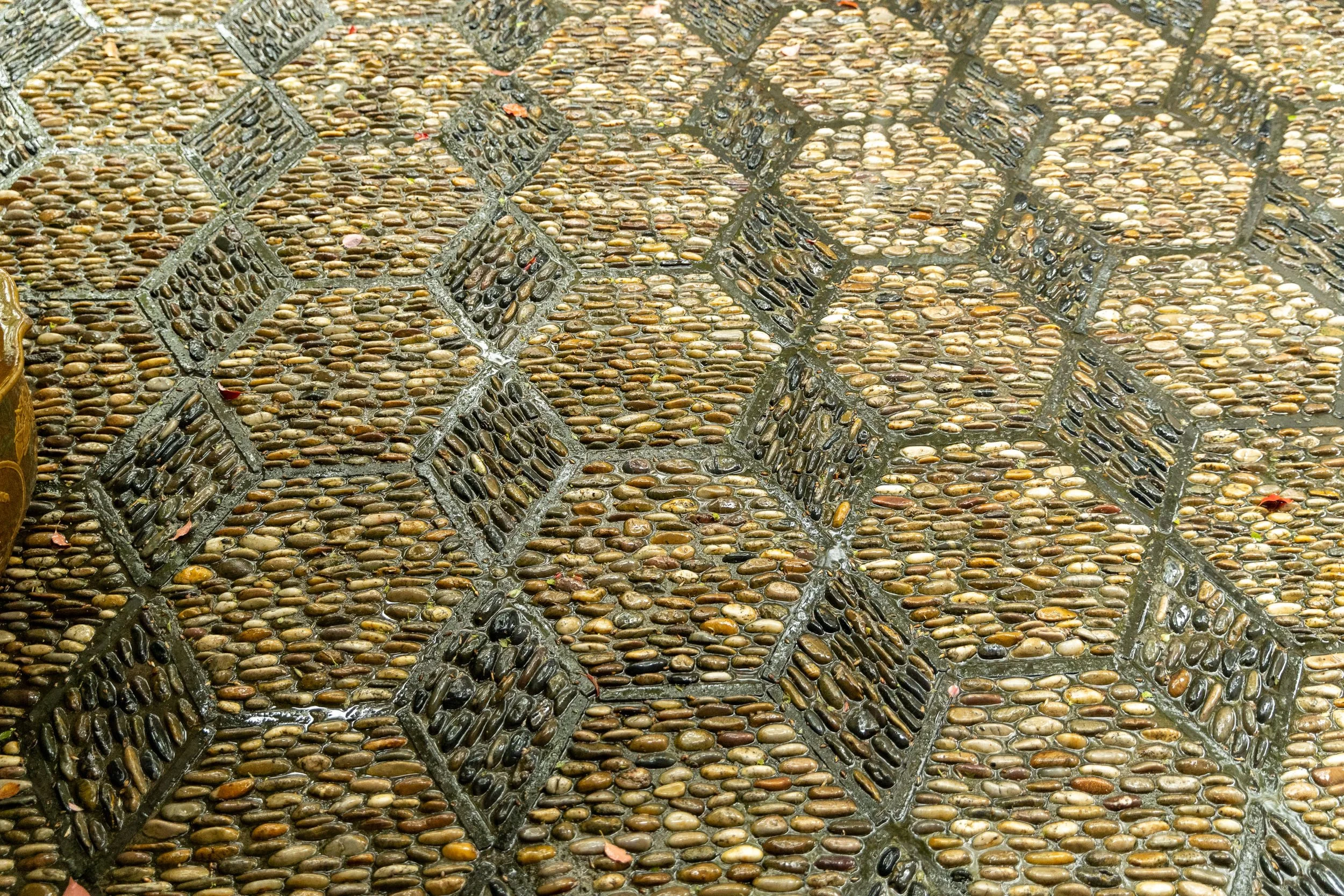 Patterned stone mosaic walkway with geometric shapes