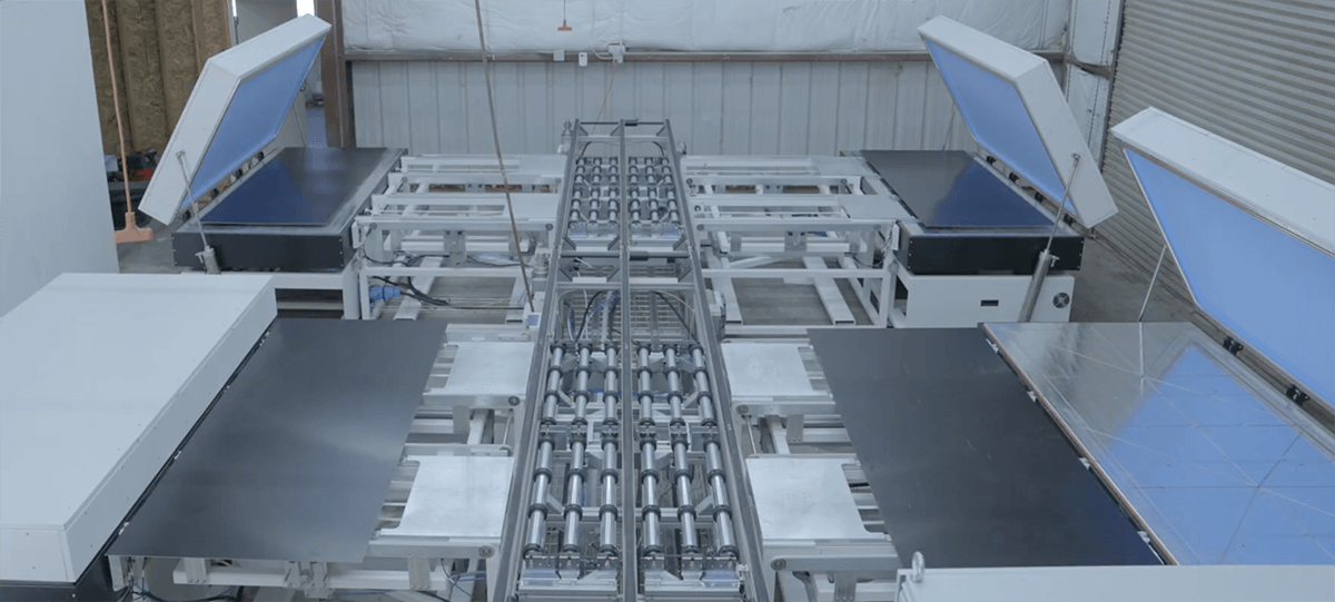 custom solar lamination equipment. Industrial conveyor system with multiple sections, some covered with blue and reflective surfaces, in a warehouse setting.
