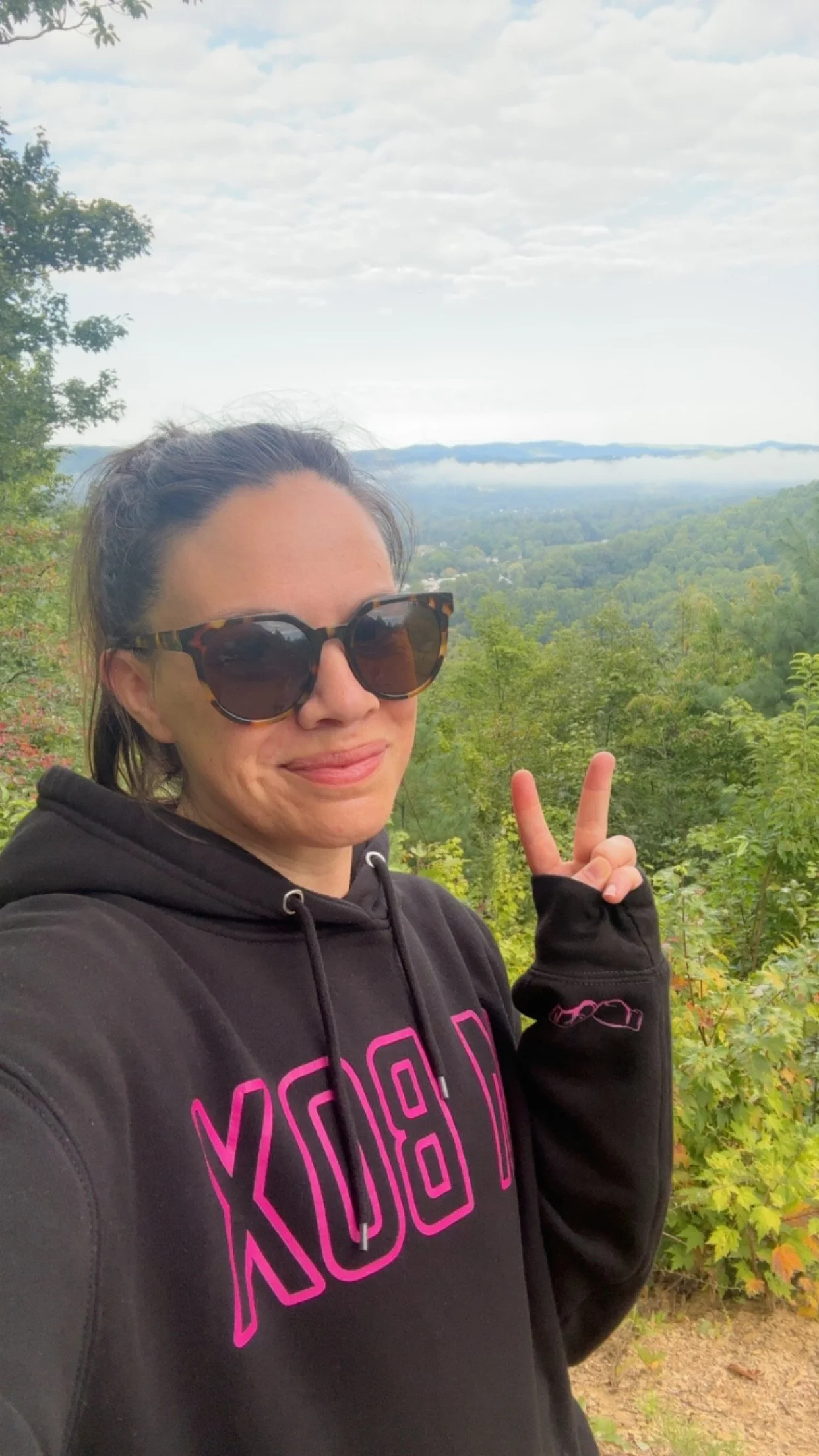 Emily wearing the Black M Box Hoodie (Pink Edit) in the mountains