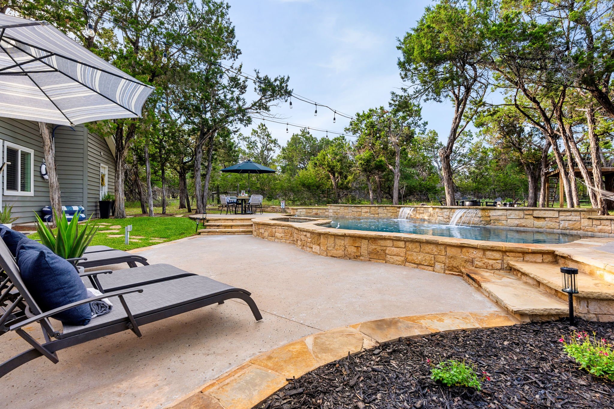 Resort-style backyard surrounded by nature with waterfall Pool & heated spa.