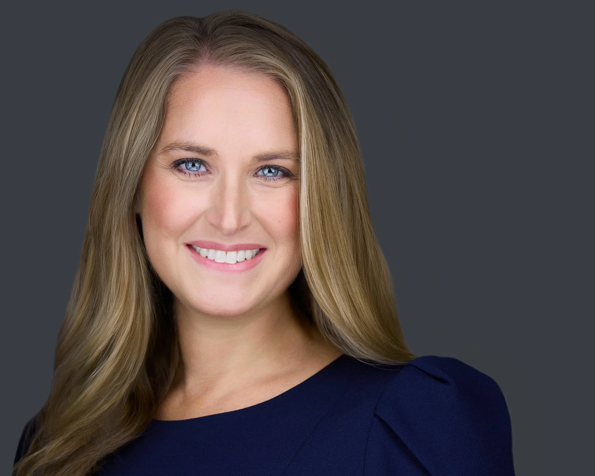 Headshot of Executive Director on grey background in blue dress. McKinney TX headshot photographer. Prosper TX headshot photographer