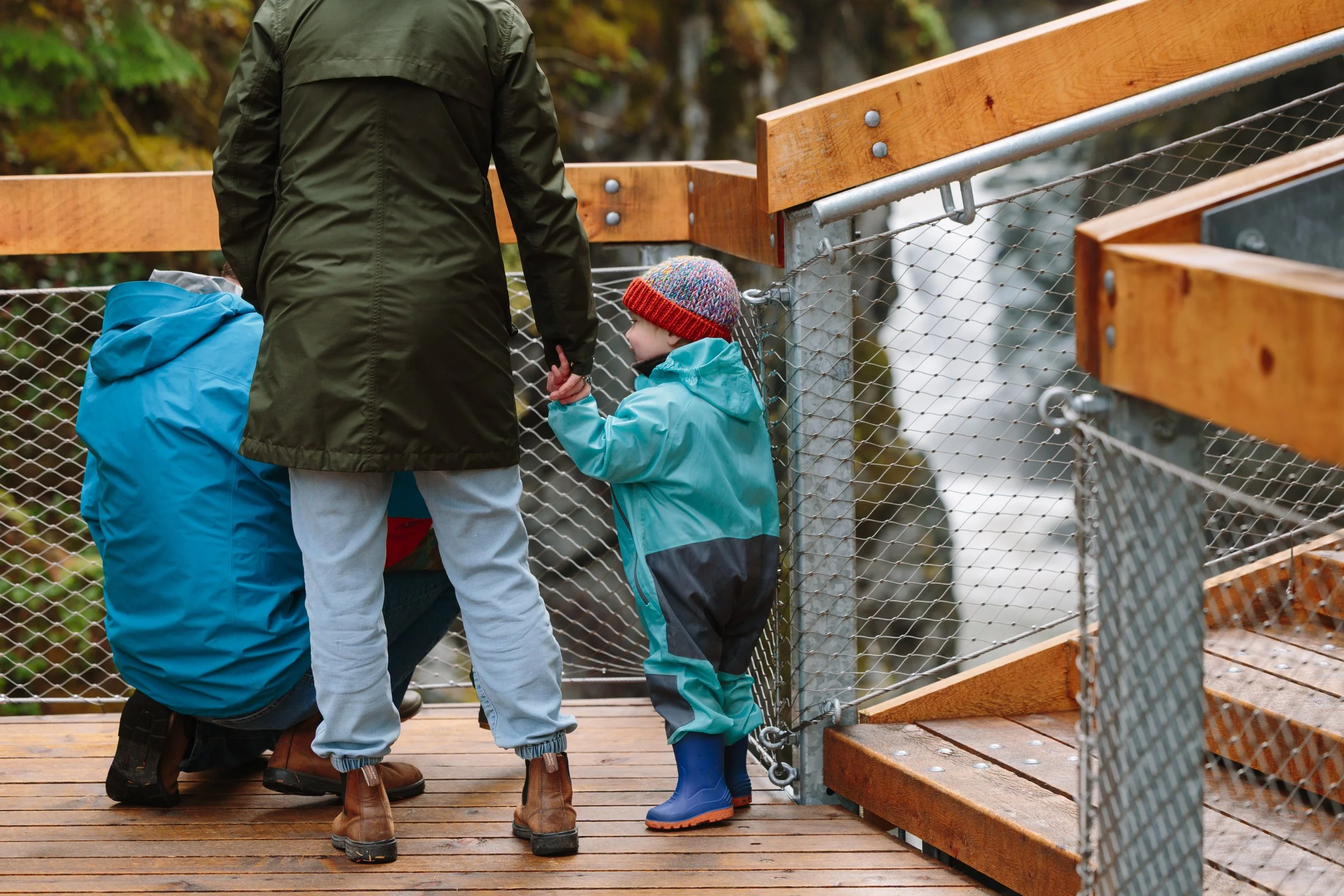 Adults and child viewing Mamquam Falls from a Squamish Canyon boardwalk viewpoint