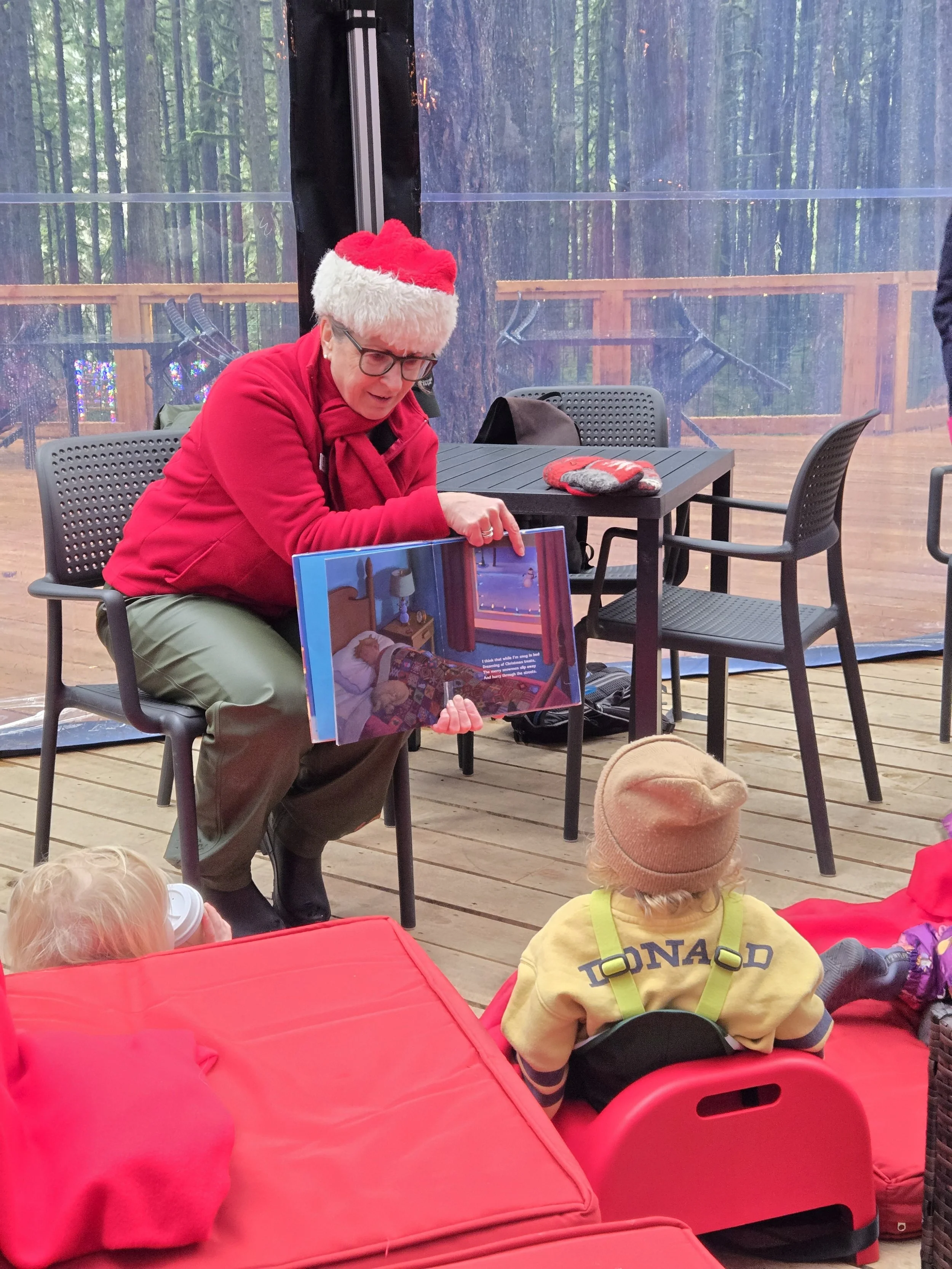 Staff member reading a children’s story to a group of kids in the Forest Lounge at Squamish Canyon.