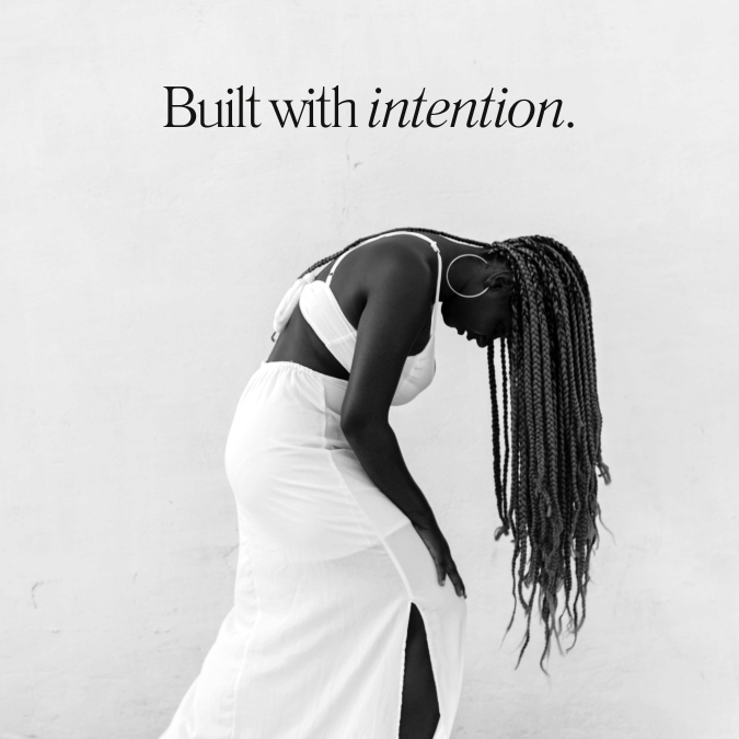 A woman in a white dress with braids is bent over, holding her leg, with the text "Built with intention" above her. Blueprint studio creative  artist web design