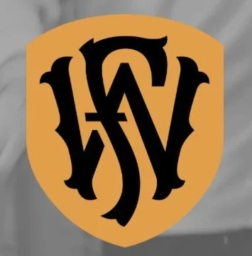 A logo with stylized black letters inside a gold shield-shaped background.