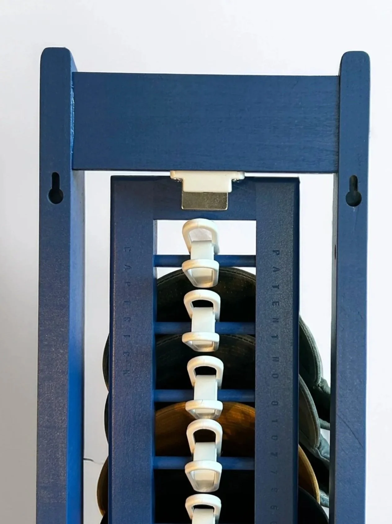 Blue wooden shoe rack with multiple pairs of shoes stored inside.
