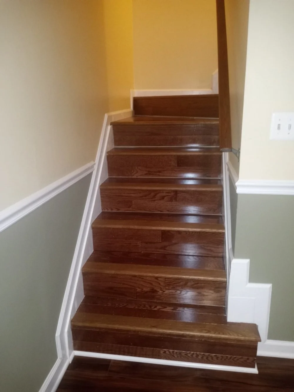 Indoor staircase with wooden steps and white trim walls