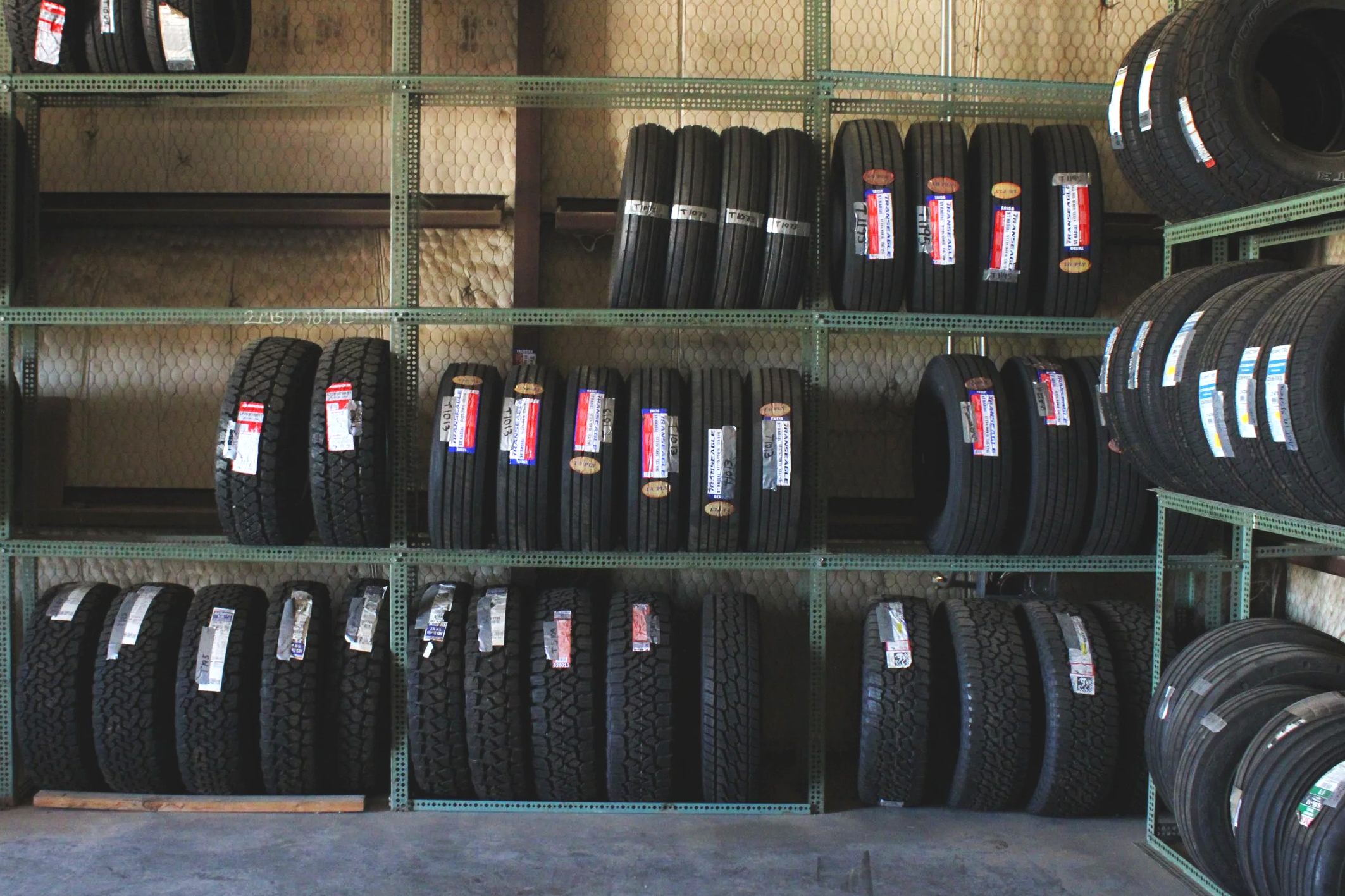 A store aisle with shelves stocked with new tires.