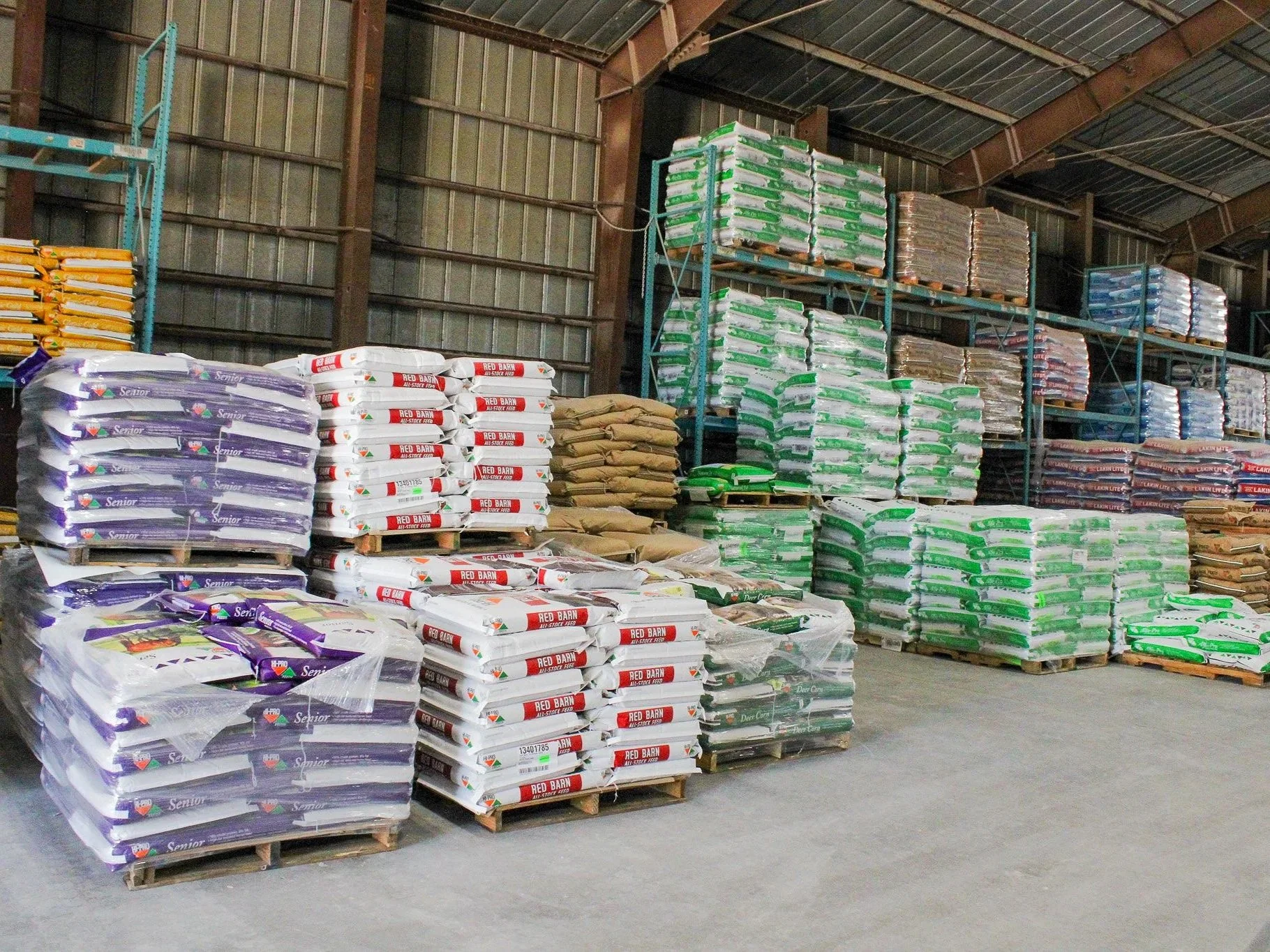 Stacks of fertilizer bags arranged on pallets inside a warehouse.