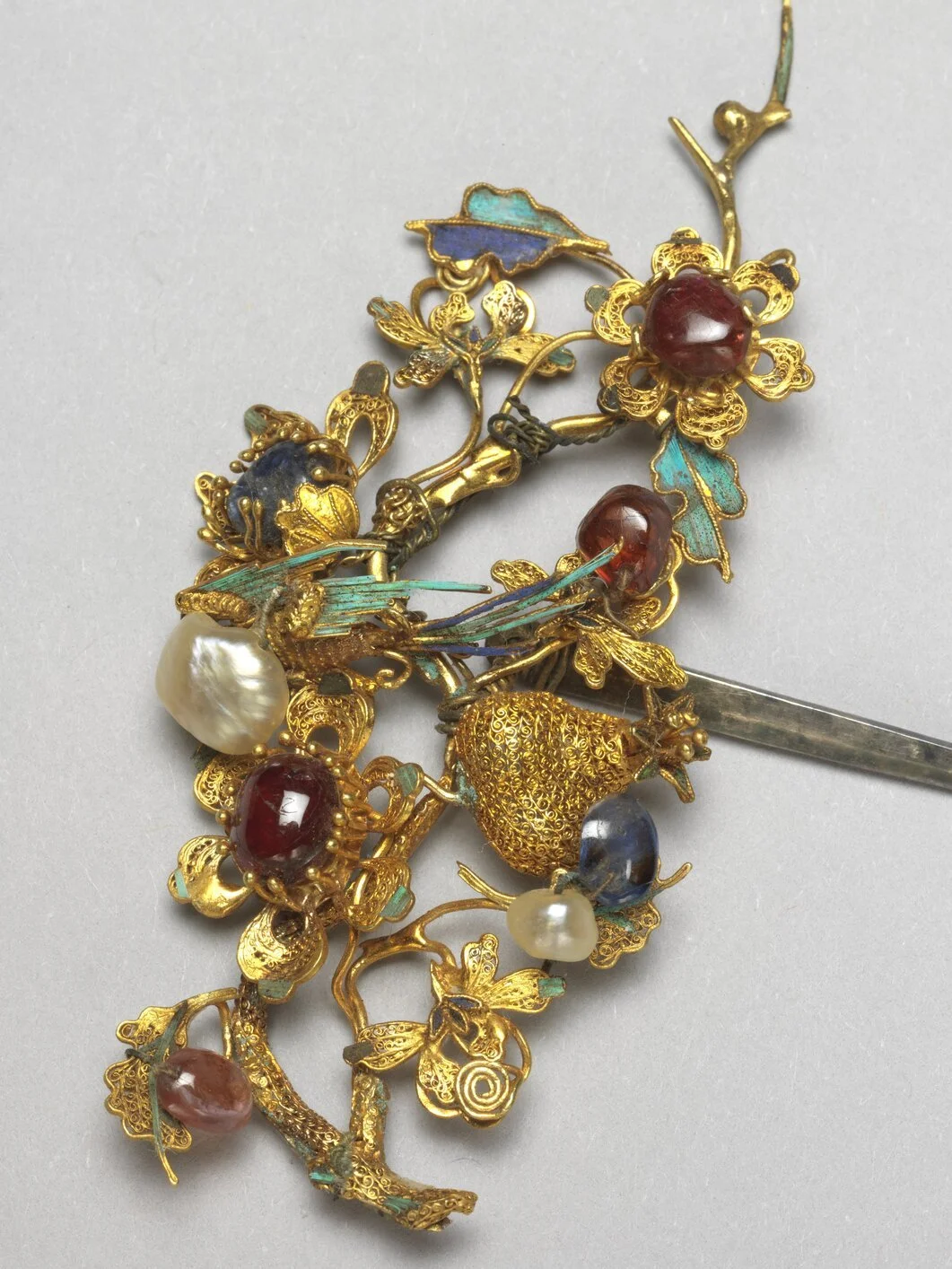An authentic Qing Dynasty imperial gold hairpin featuring intricate filigree wirework, inlaid with red cabochon gemstones, natural pearls, and turquoise kingfisher feather inlay.