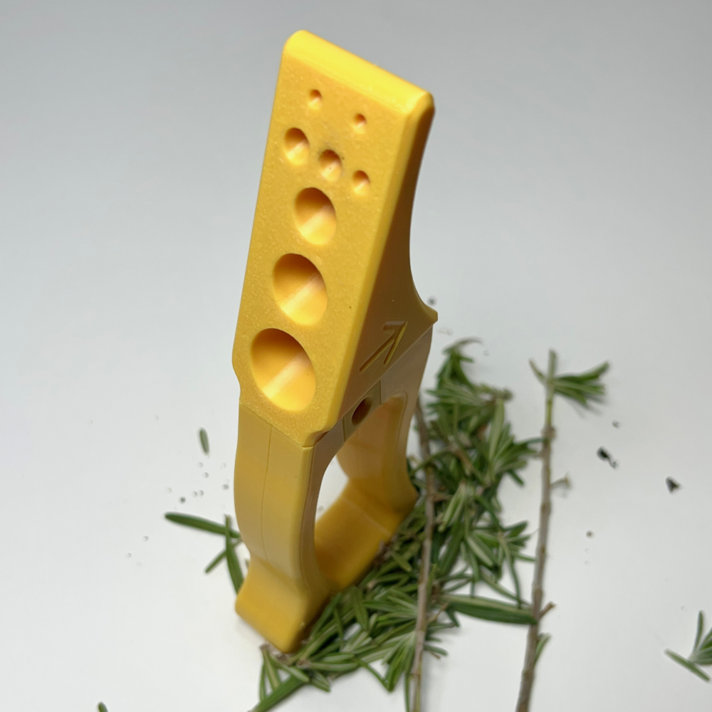 Herb stripper standing upright, featuring the variety of hole sizes