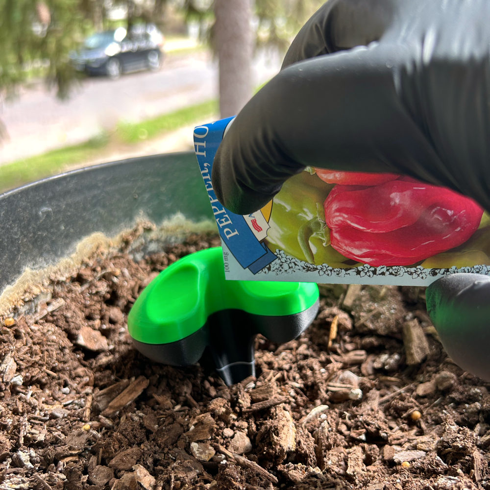 Top view of tool, demonstrating slide with envelope of seeds