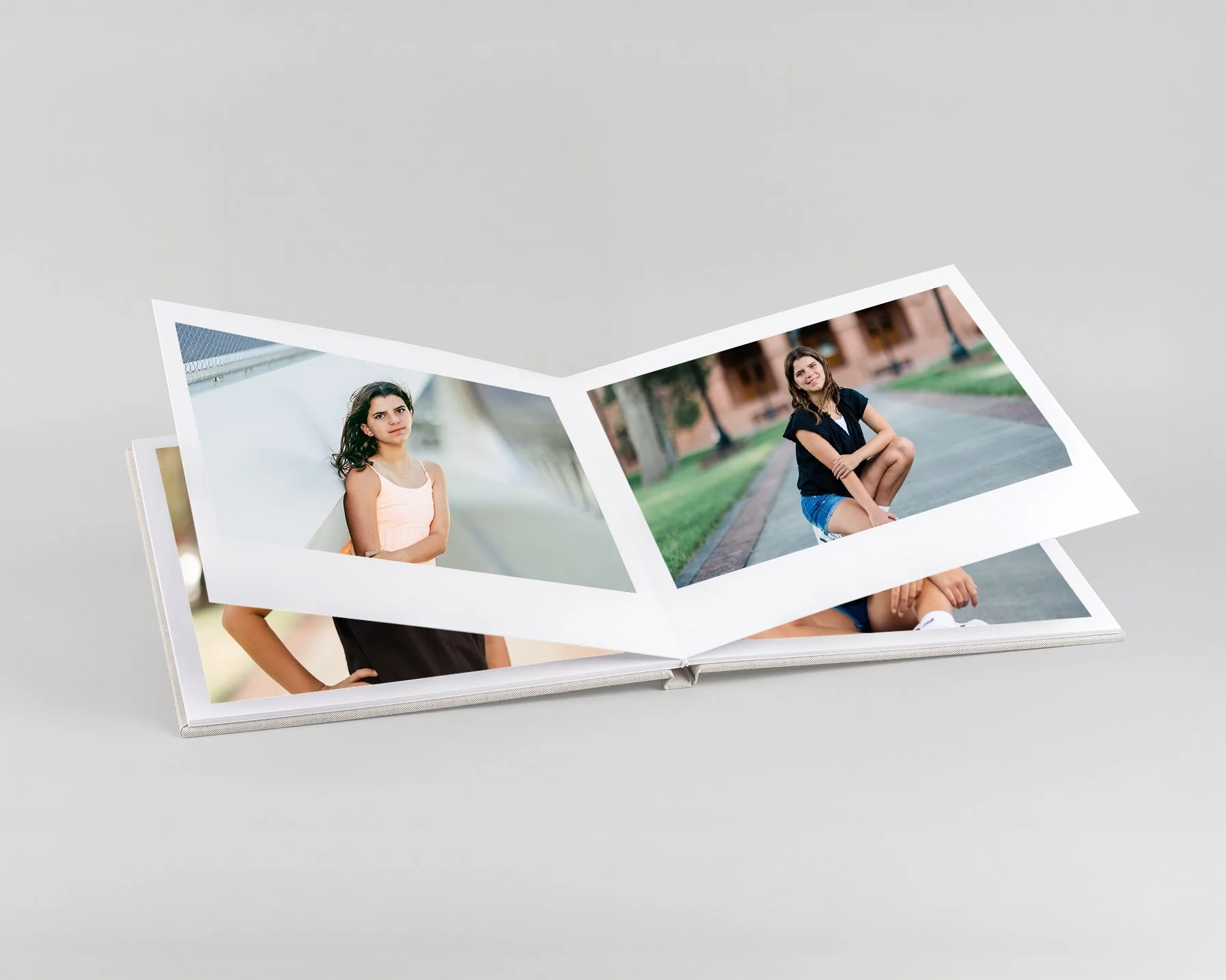 Teen boy sitting on a park bench, wearing a black leather jacket and blue jeans, with a dog tag necklace, looking at the camera with a serious expression, outdoors with green trees in the background.