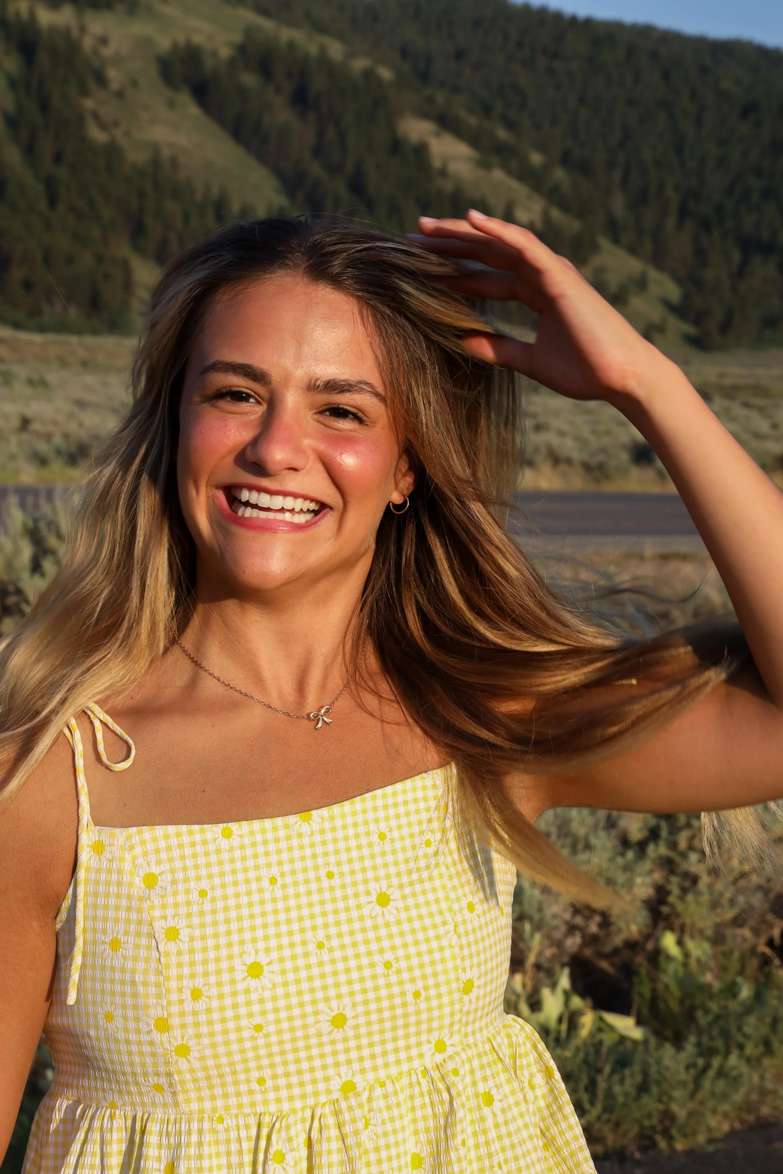 Smiling young woman in yellow sundress under golden sunset – natural light portrait photography by Kasden Grasse.