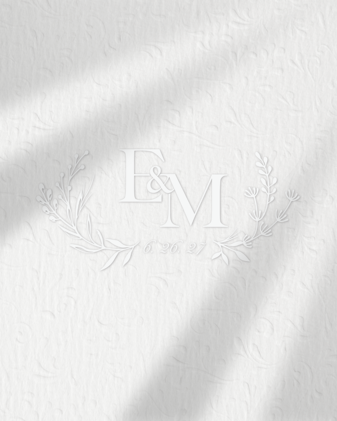 White textured paper with embossed custom wedding monogram. 