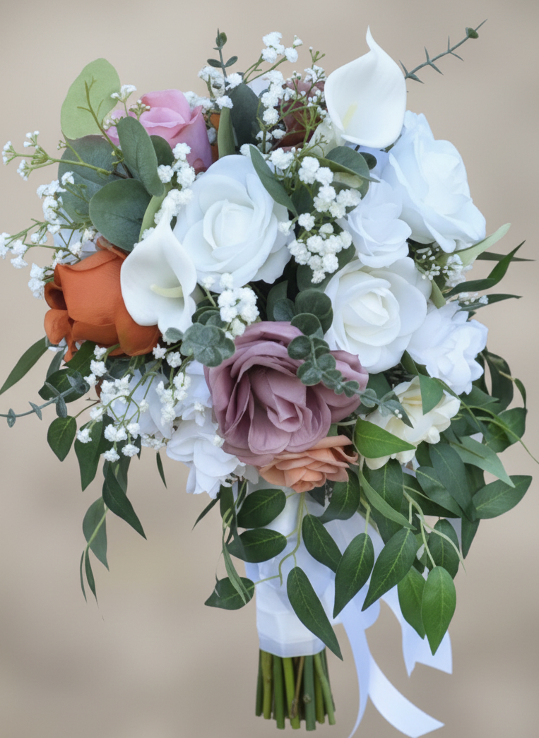 A close-up of a bridal bouquet with white, peach, pink, and lavender roses, white calla lilies, and greenery, wrapped with a white ribbon.