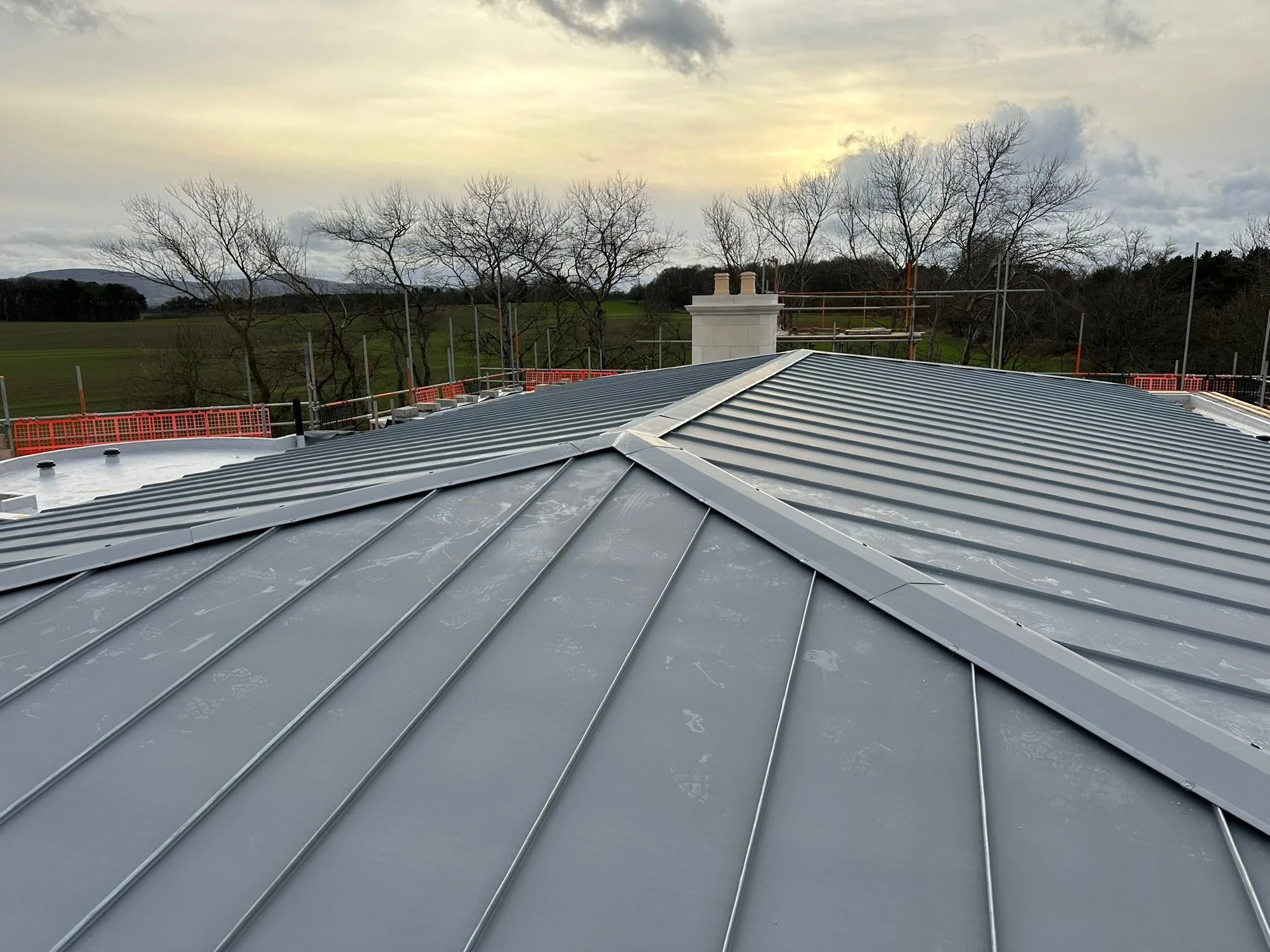 Metal roof installation with scenic background