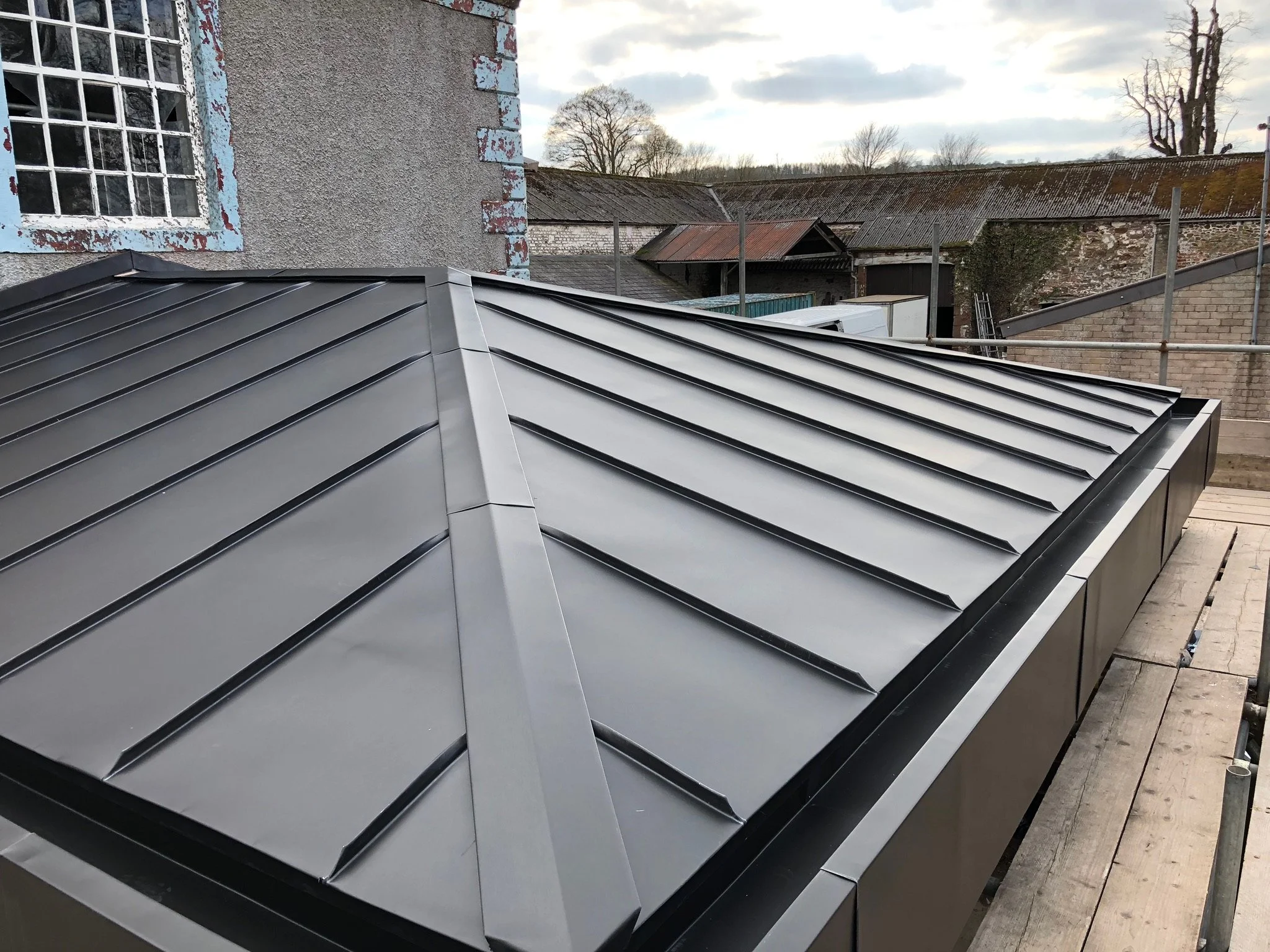 Modern metal roofing installation with standing seam design