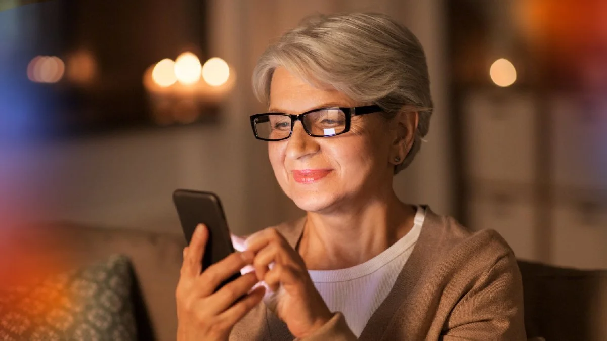 Older woman using a smartphone, representing how patients increasingly access healthcare information and digital services through online channels.
