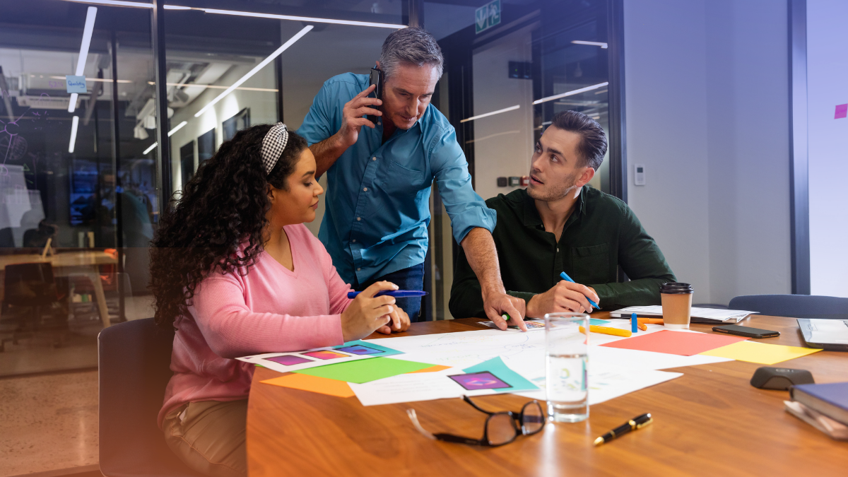 Two professionals organizing ideas and workflows on a glass board with sticky notes, representing collaborative planning and the strategic implementation of artificial intelligence.