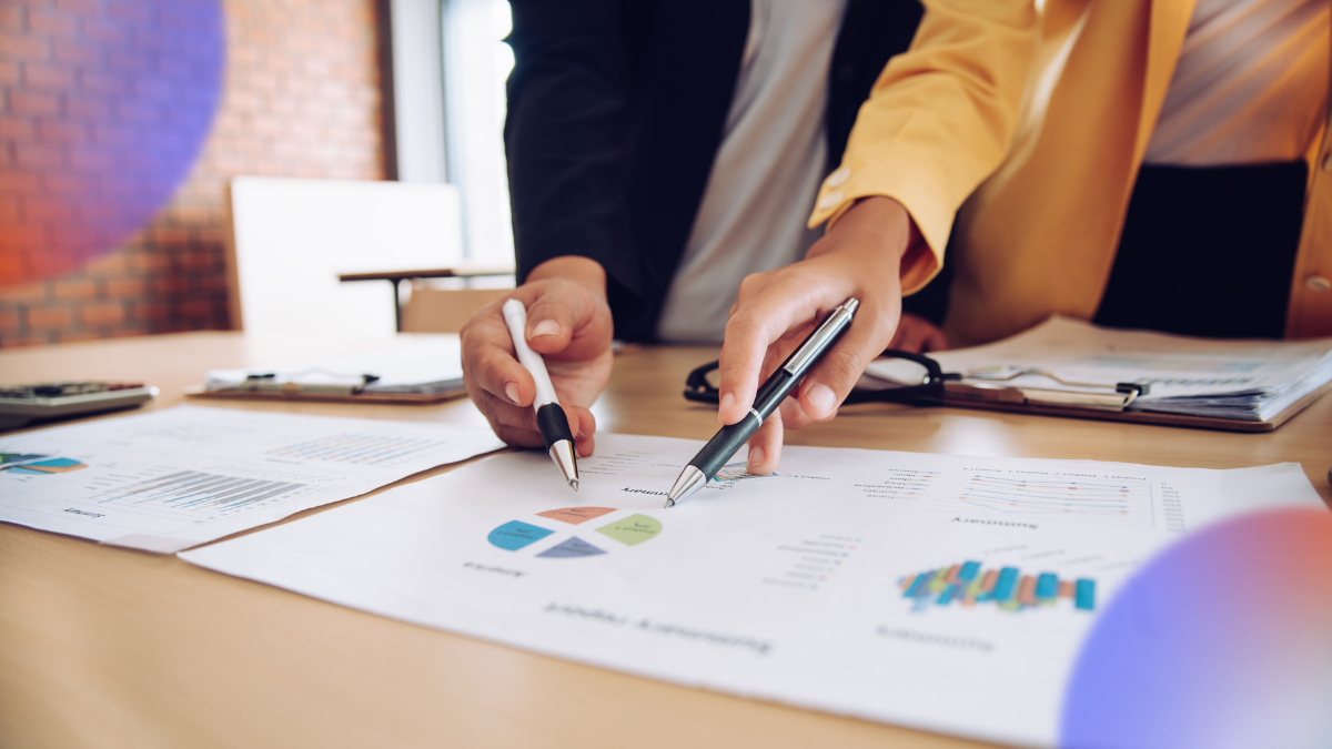 Business professionals reviewing reports, charts, and performance metrics during a planning session, illustrating the implementation of a Business Intelligence strategy and data-driven decision-making.