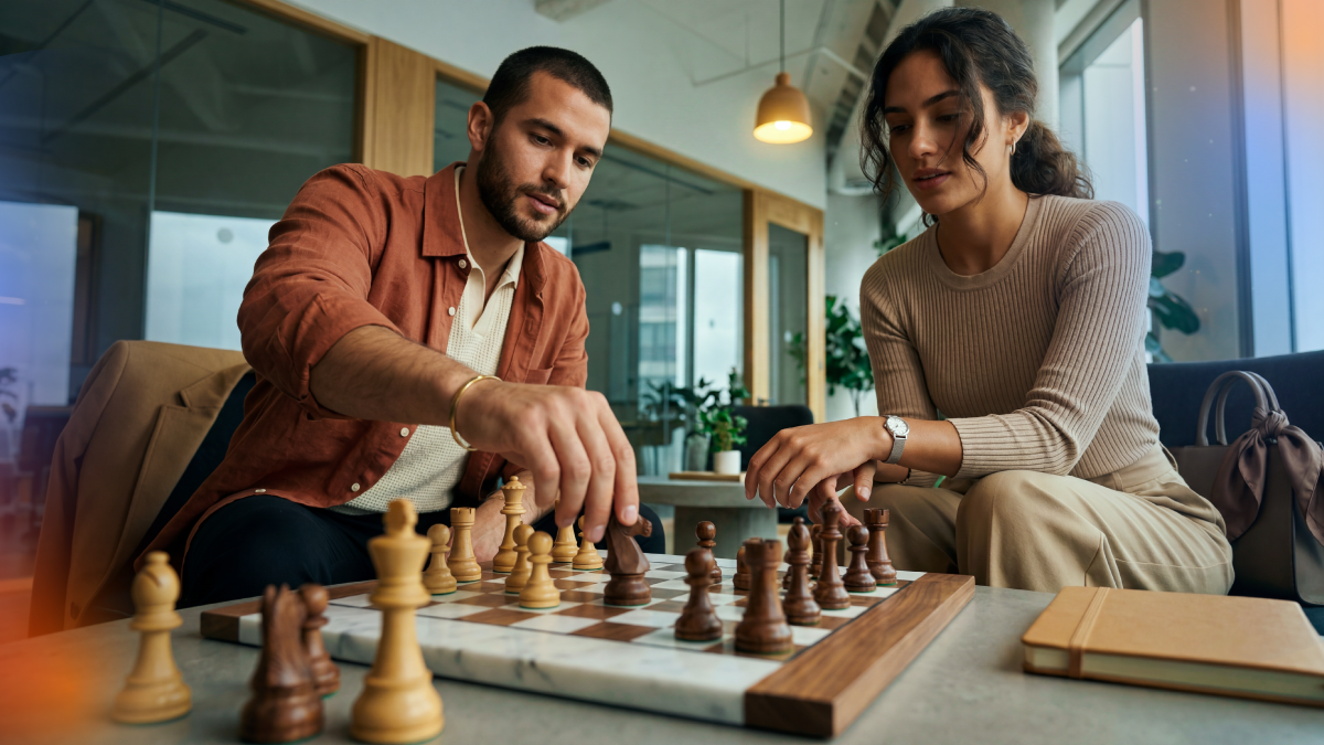 Two professionals playing chess in an office setting, representing strategic planning, decision-making, and the importance of aligning HubSpot with business objectives before implementation.