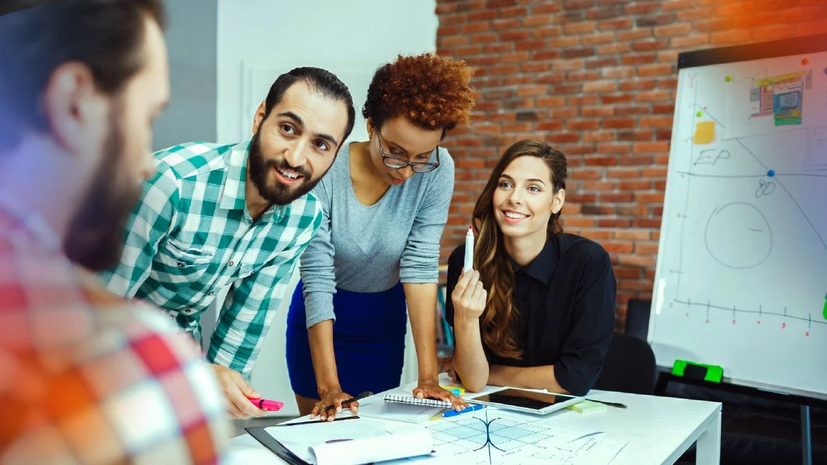 Team of business professionals in a strategic planning session around a whiteboard, representing the challenge of managing growth and new opportunities.