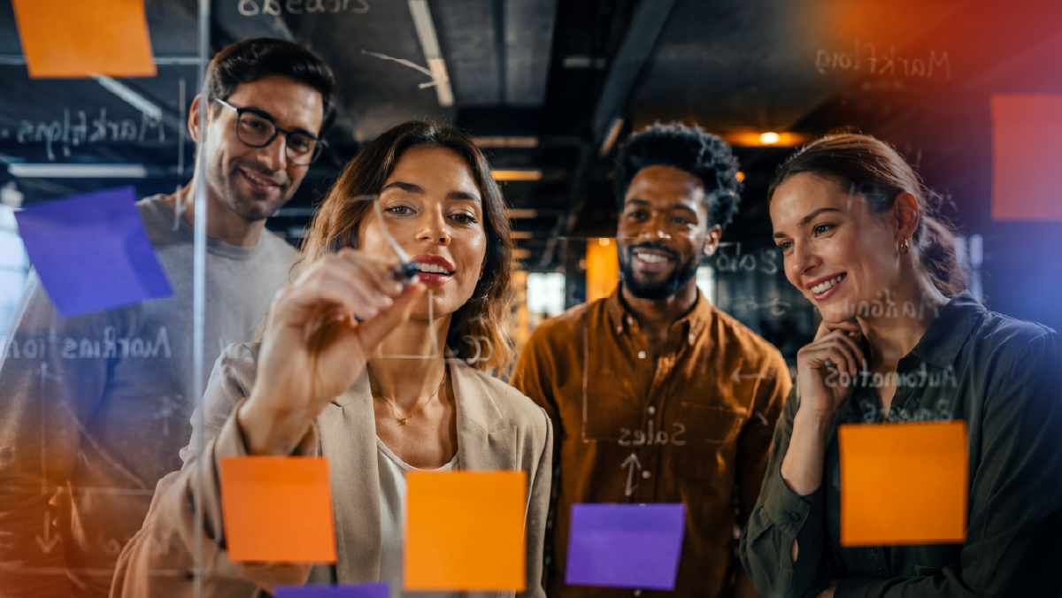 Business team collaborating around a planning board with notes and workflow diagrams, representing HubSpot onboarding, team adoption, strategic implementation, and continuous optimization guided by a certified HubSpot Partner.