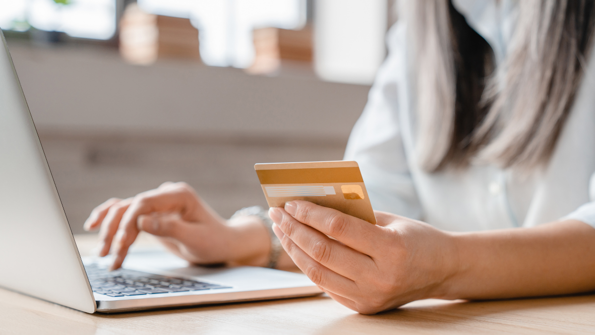 Customer making an online purchase by entering payment details with a credit card while using a laptop, representing secure digital payments and the final stage of the e-commerce buying journey.