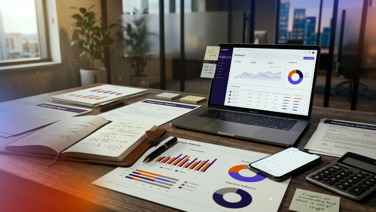 Workspace with business reports, planning documents, and a CRM dashboard on a laptop, representing the strategic design of data architecture, performance measurement, and HubSpot implementation planning.