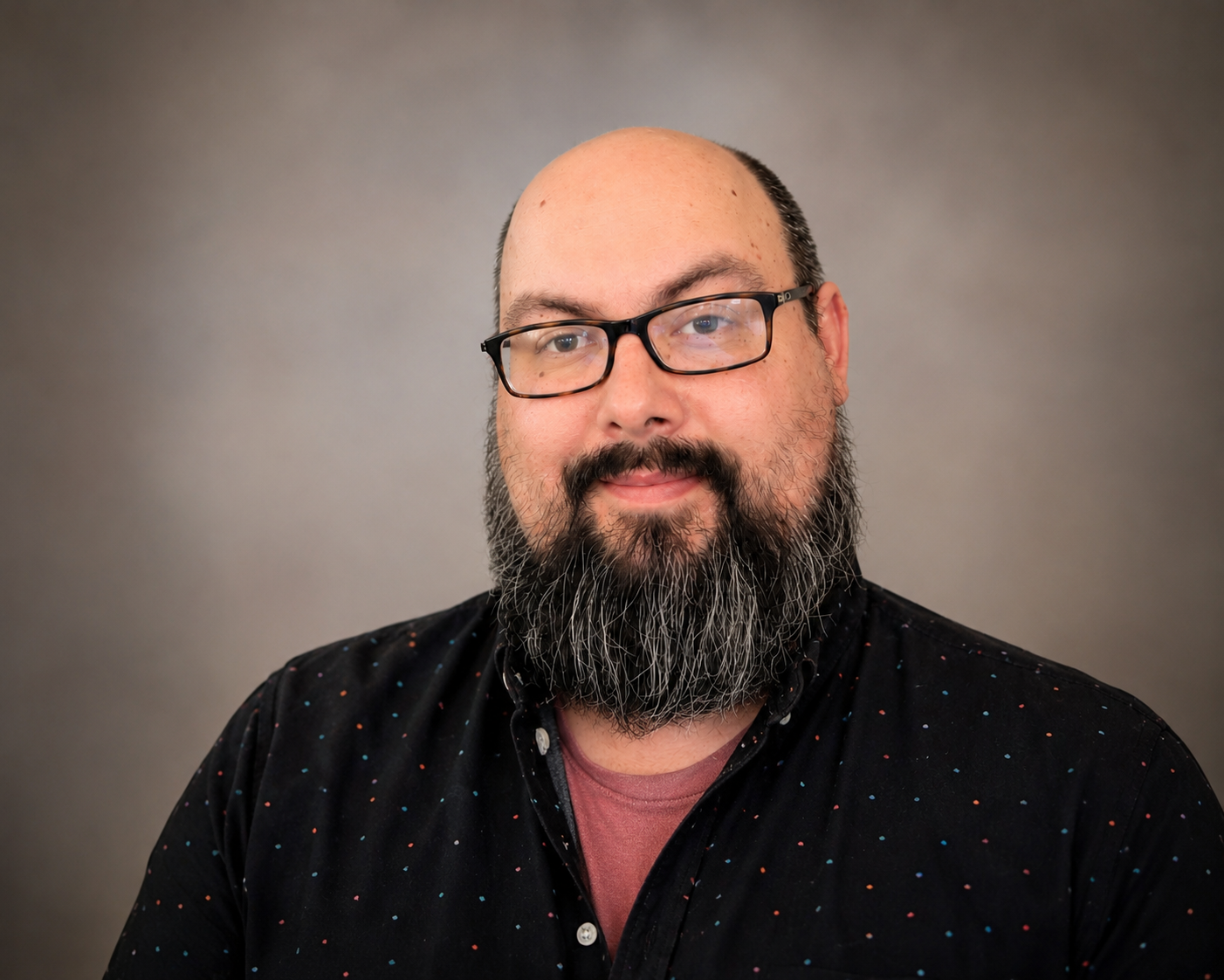 Man in black shirt with beard smiling for photo