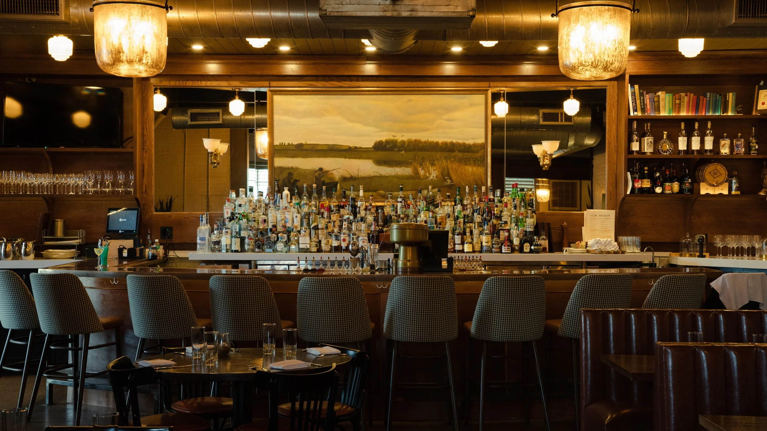 People sitting around a bar counter engaged in conversation at a restaurant or bar.