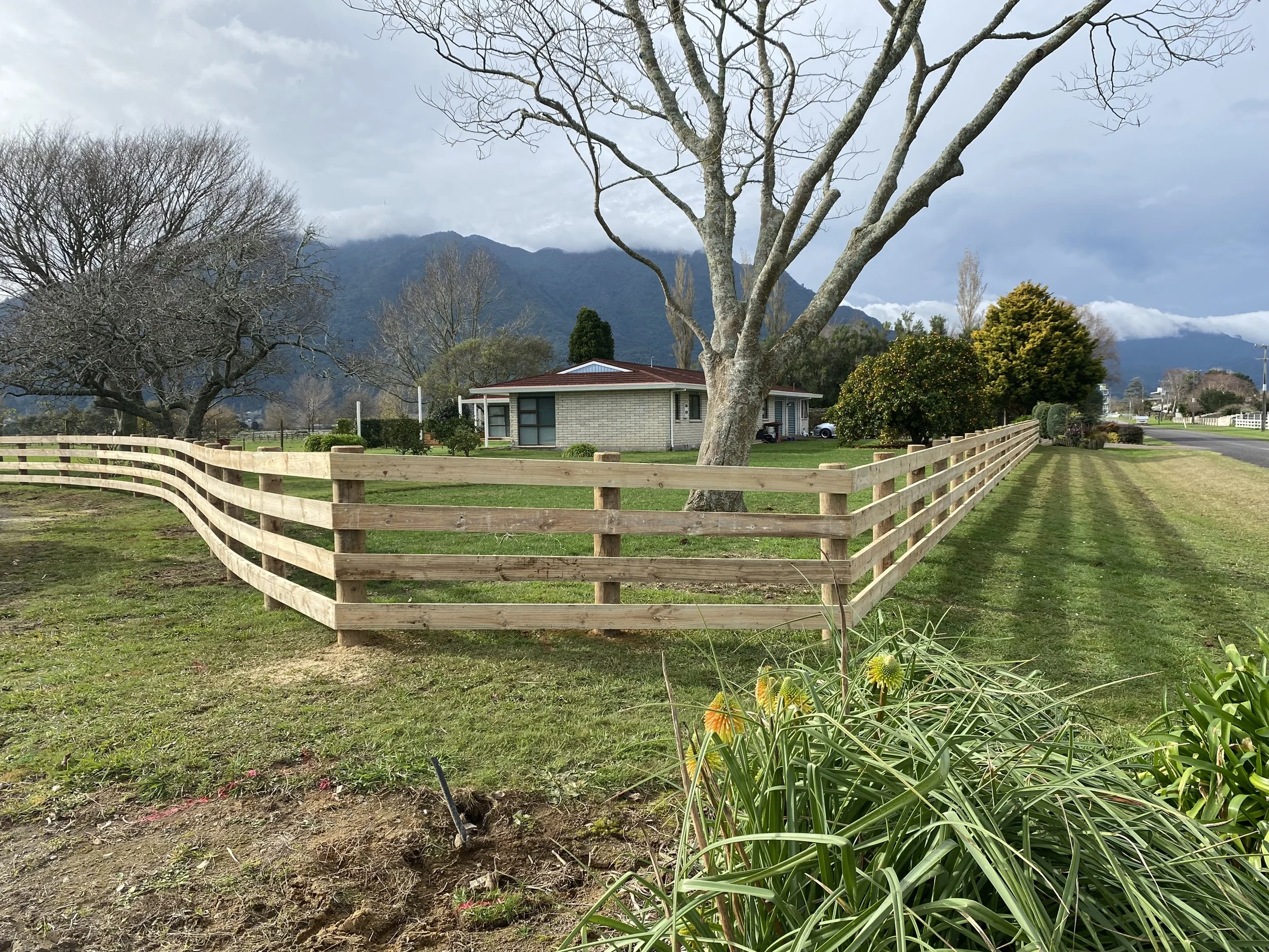 Wooden fence and house with mountain backdrop
