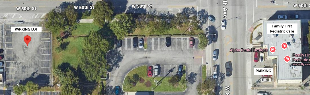 Aerial view of a parking lot, surrounding trees, and nearby buildings with businesses labeled 'Family First Pediatric Care.'