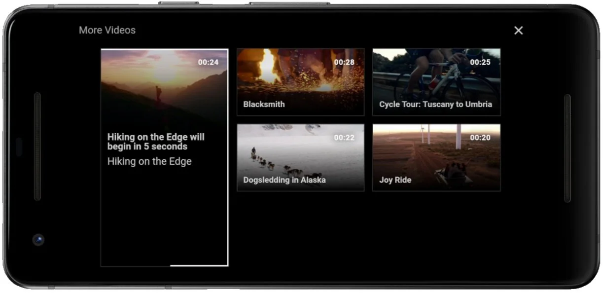 Smartphone screen displaying a video playlist interface with thumbnails for videos titled "Hiking on the Edge," "Blacksmith," "Cycle Tour: Tuscany to Umbria," "Dogsledding in Alaska," and "Joy Ride."