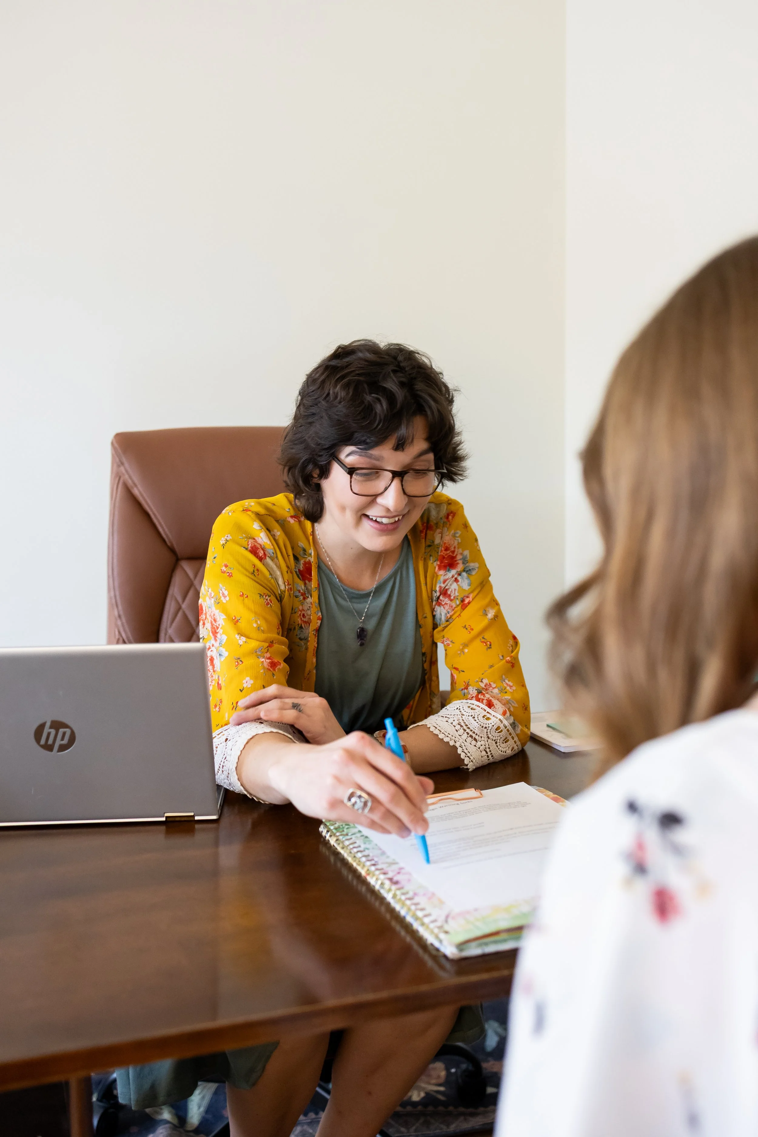 Dr. Bobi Farrow reviewing wellness plan with a client at her desk in the Lincoln, Nebraska office