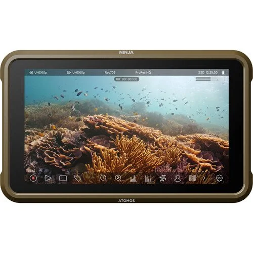 A digital monitor displaying an underwater coral reef scene with fish swimming around colorful coral formations.