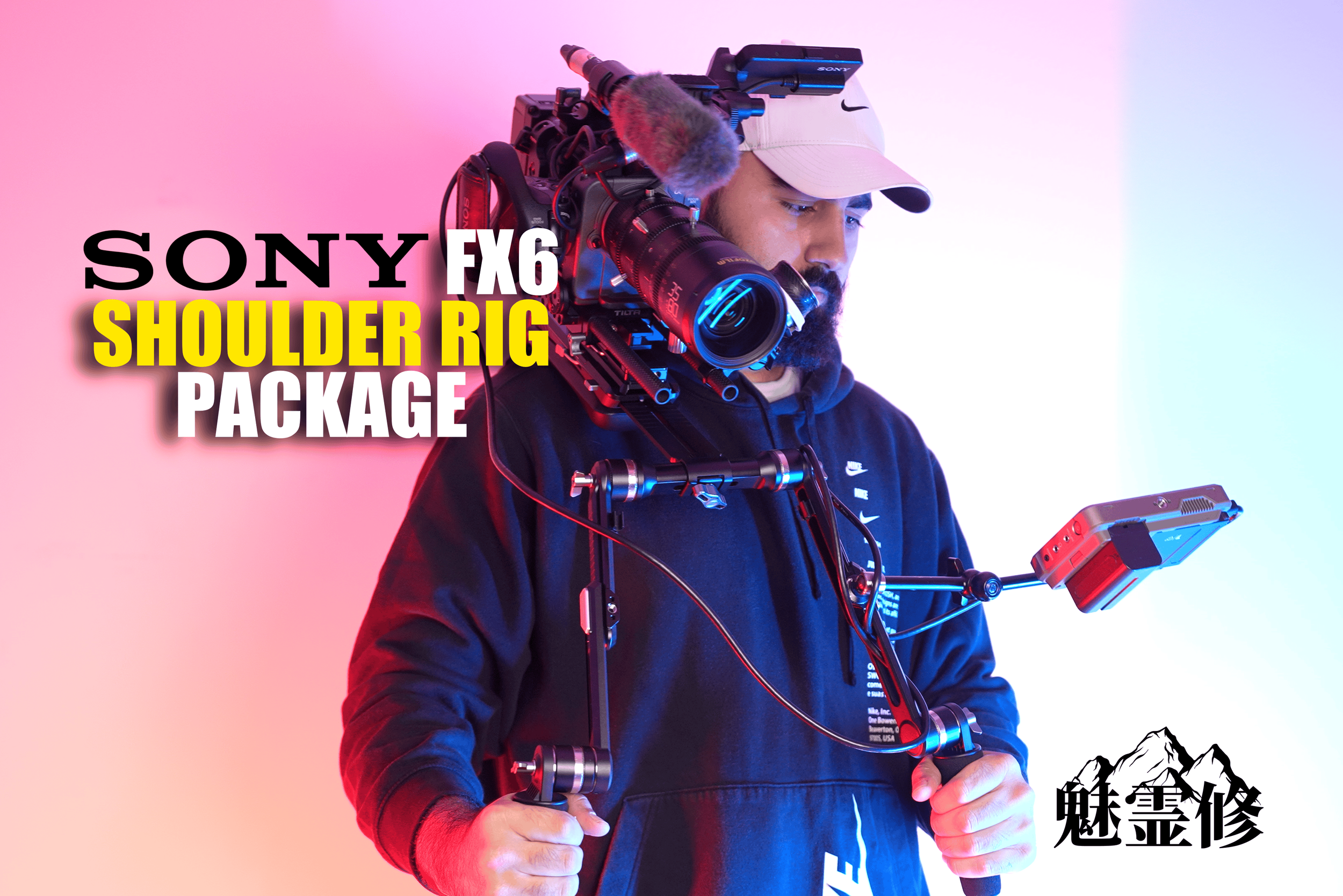 A man wearing a beige cap and dark hoodie holding a professional video camera on his shoulder. The background features a gradient of pink and light blue, with black Asian characters at the bottom right corner.