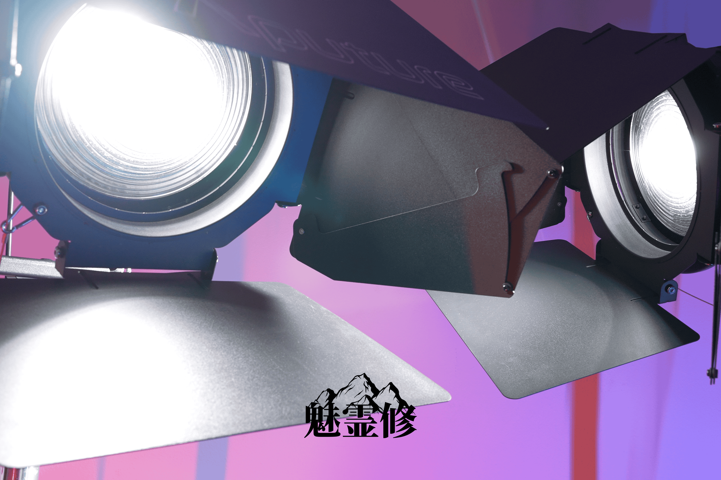 Close-up of two stage lights with metal reflectors, mounted on a purple and pink gradient background. There is Chinese text at the bottom of the image.