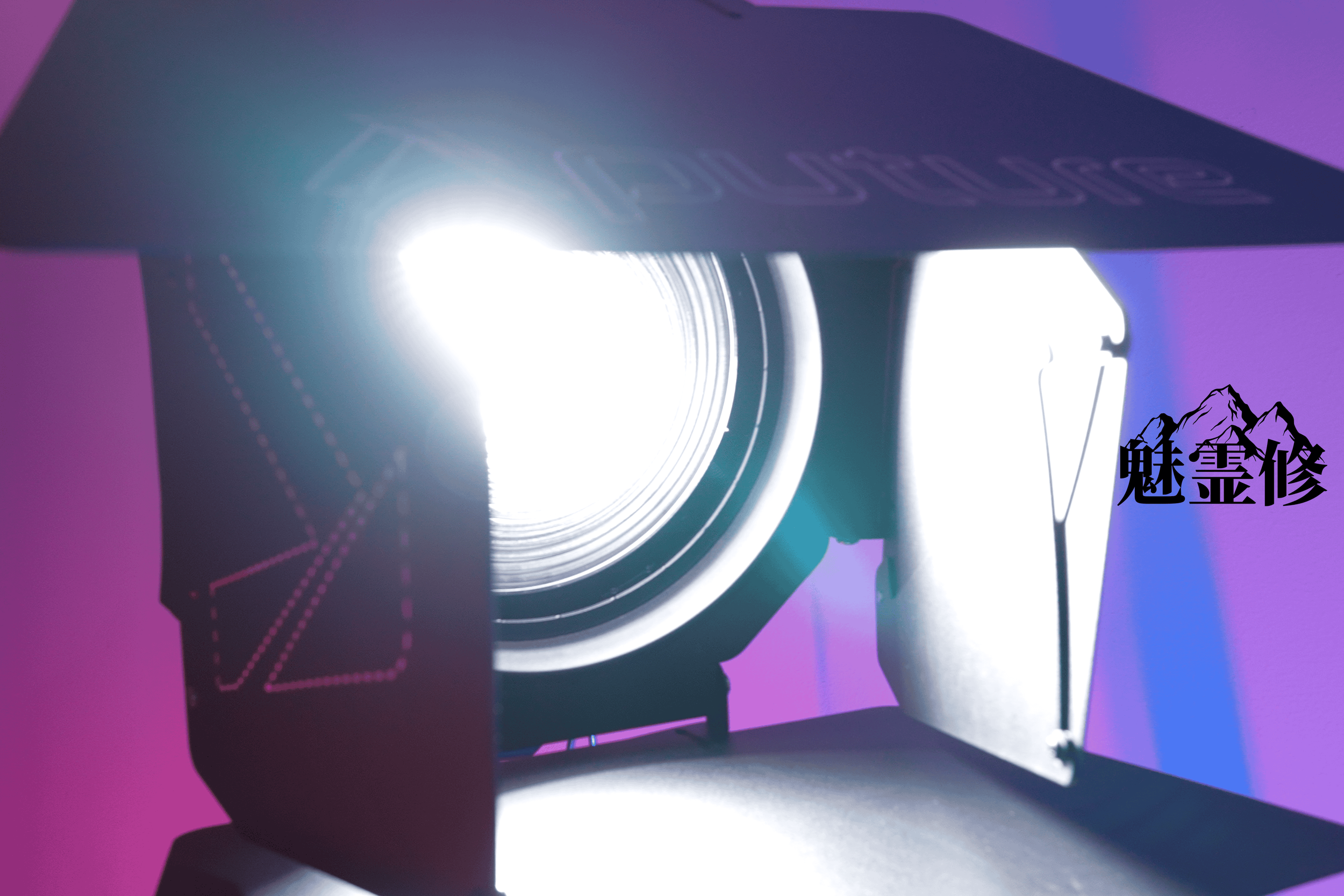 Close-up of an Aputure LS 600d Pro cinema light emitting bright light against a purple and blue background.