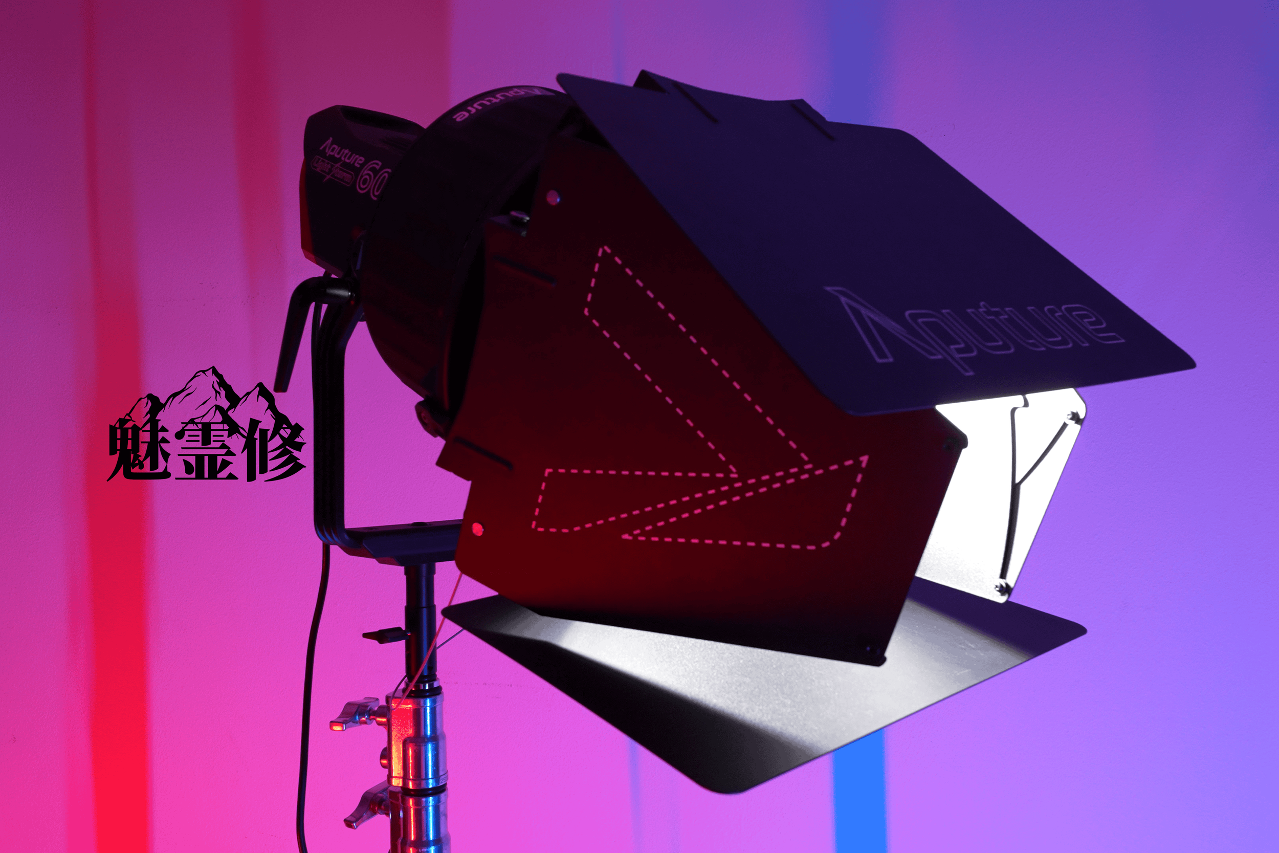 A professional photography lighting setup with a black light reflecting off the background, creating a colorful gradient in pink, purple, and blue hues.