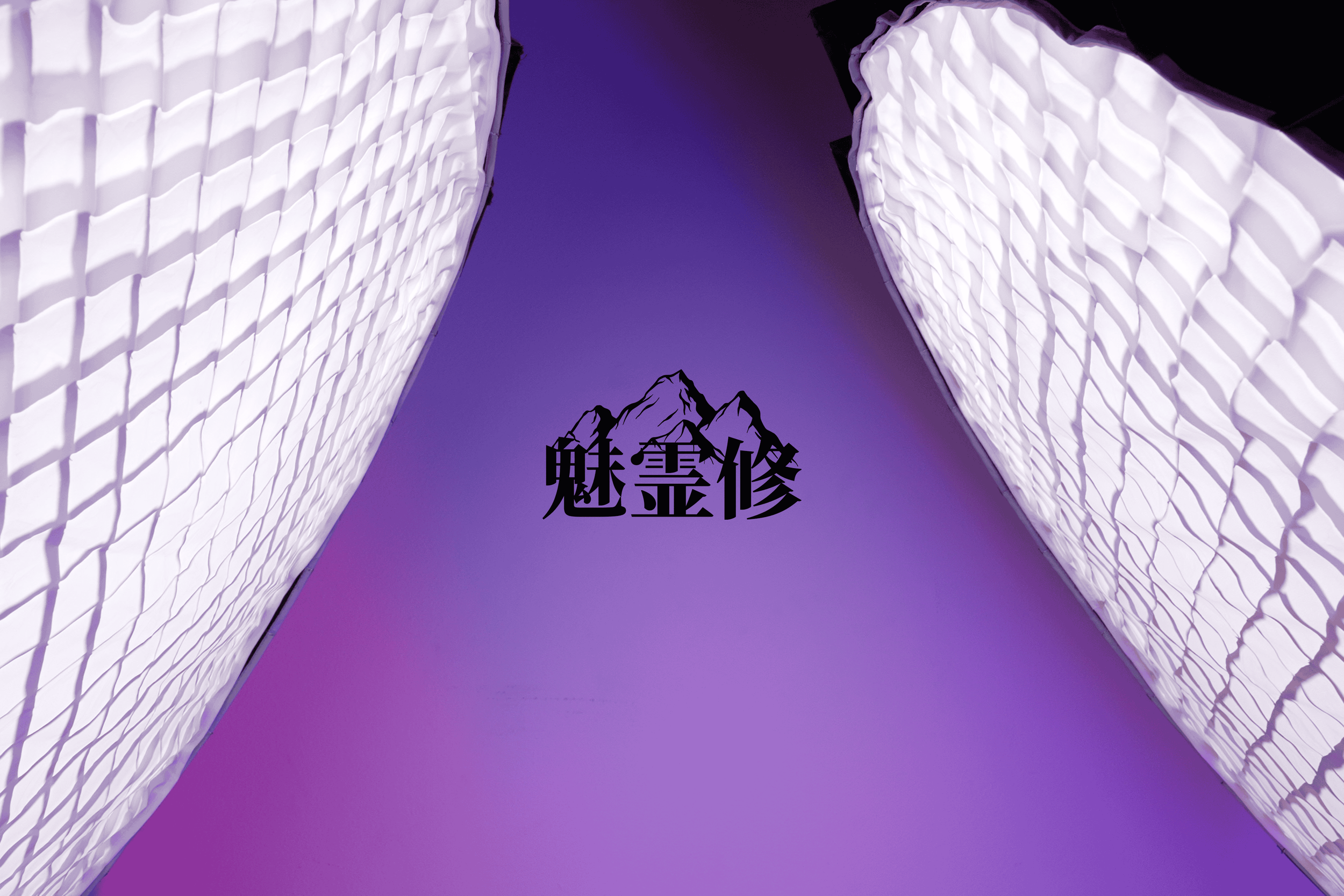 Looking up at two illuminated modern buildings with textured surfaces against a purple sky, with black Chinese characters and mountain outline in the center.