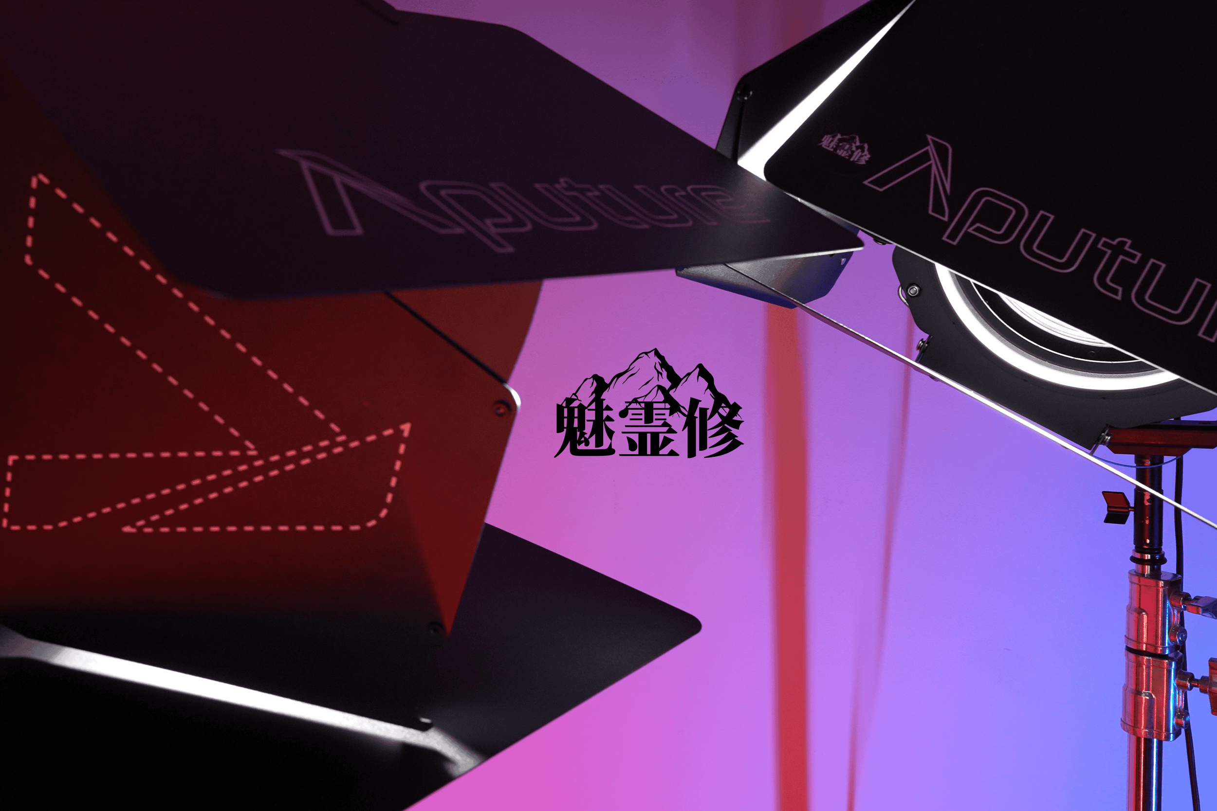 Close-up of a computer graphics or design setup with black surfaces, purple and red lighting, and Chinese characters with mountain imagery.
