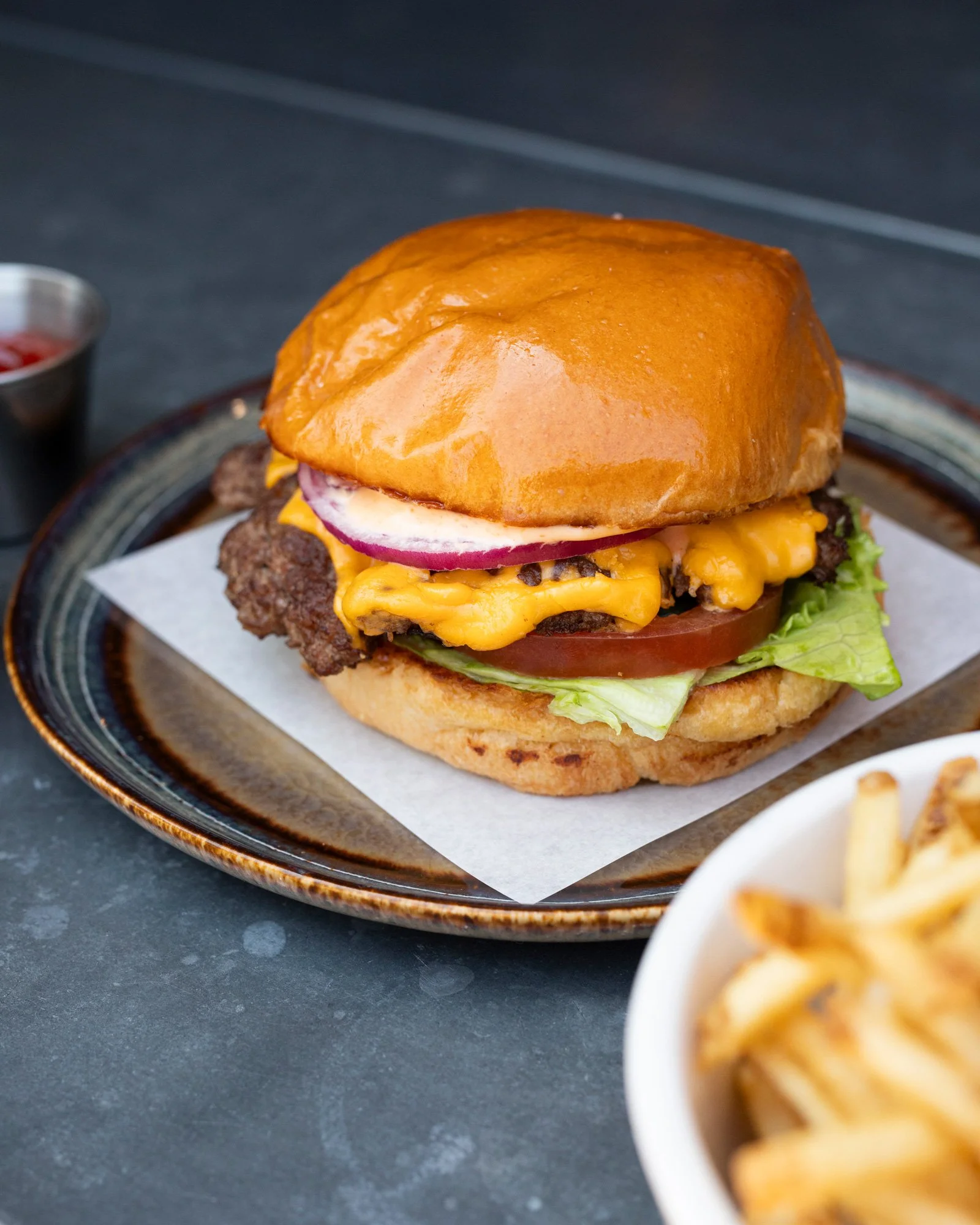 Photo du burger de bœuf avec frites chez zinqué Paris, restaurant franco-californien