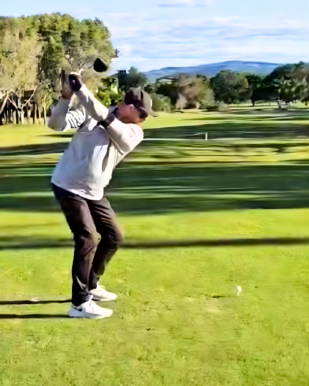 A person playing golf on a golf course during daytime.
