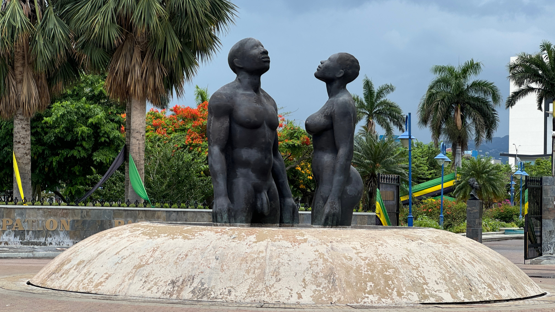 A bronze statue of two nude people facing each other, located outdoors at the emancipation park in Kingston Jamaica.