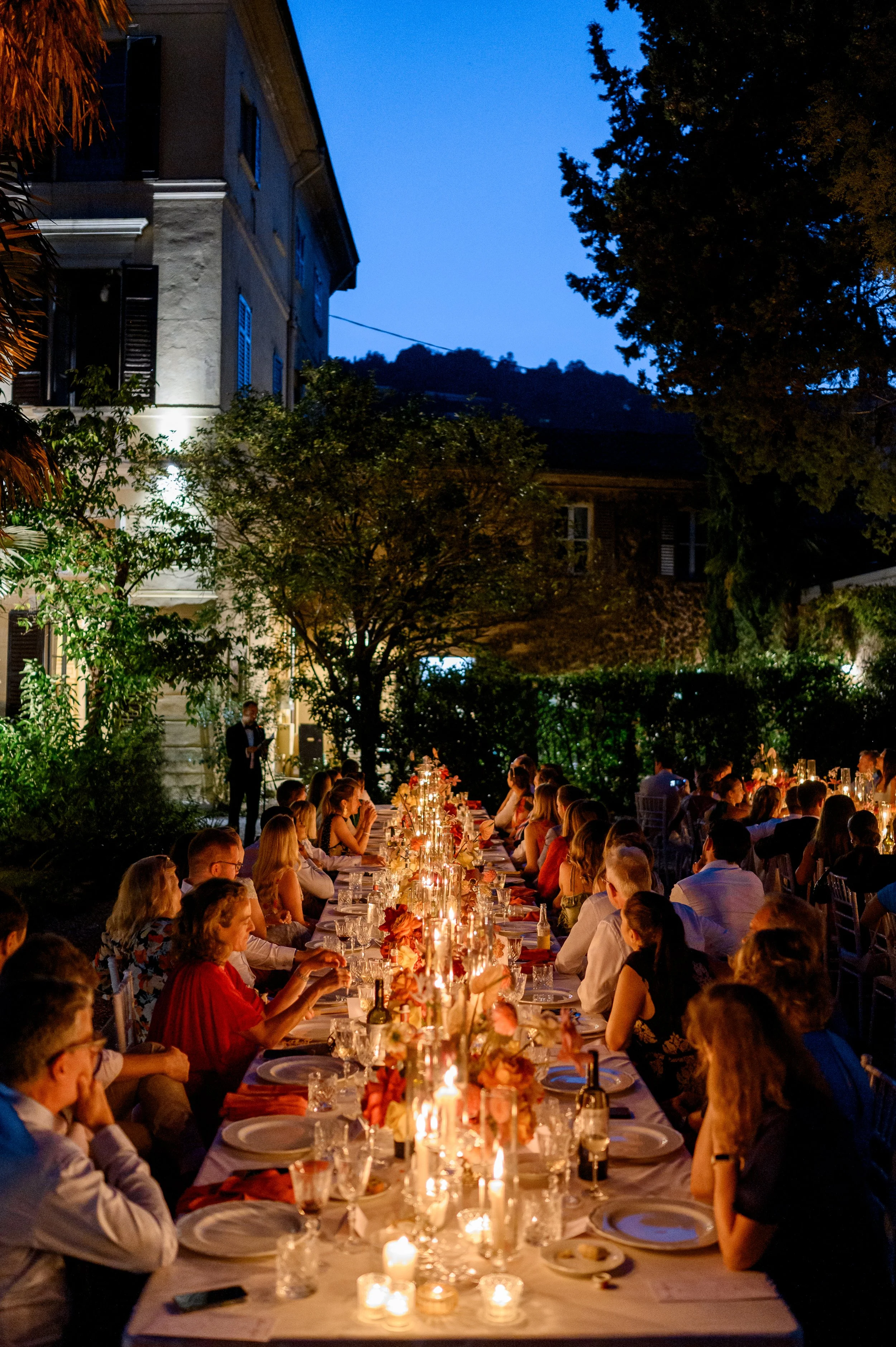 Candlelit wedding reception at an Italian villa featuring long banquet tables, floral styling, and destination wedding guests.