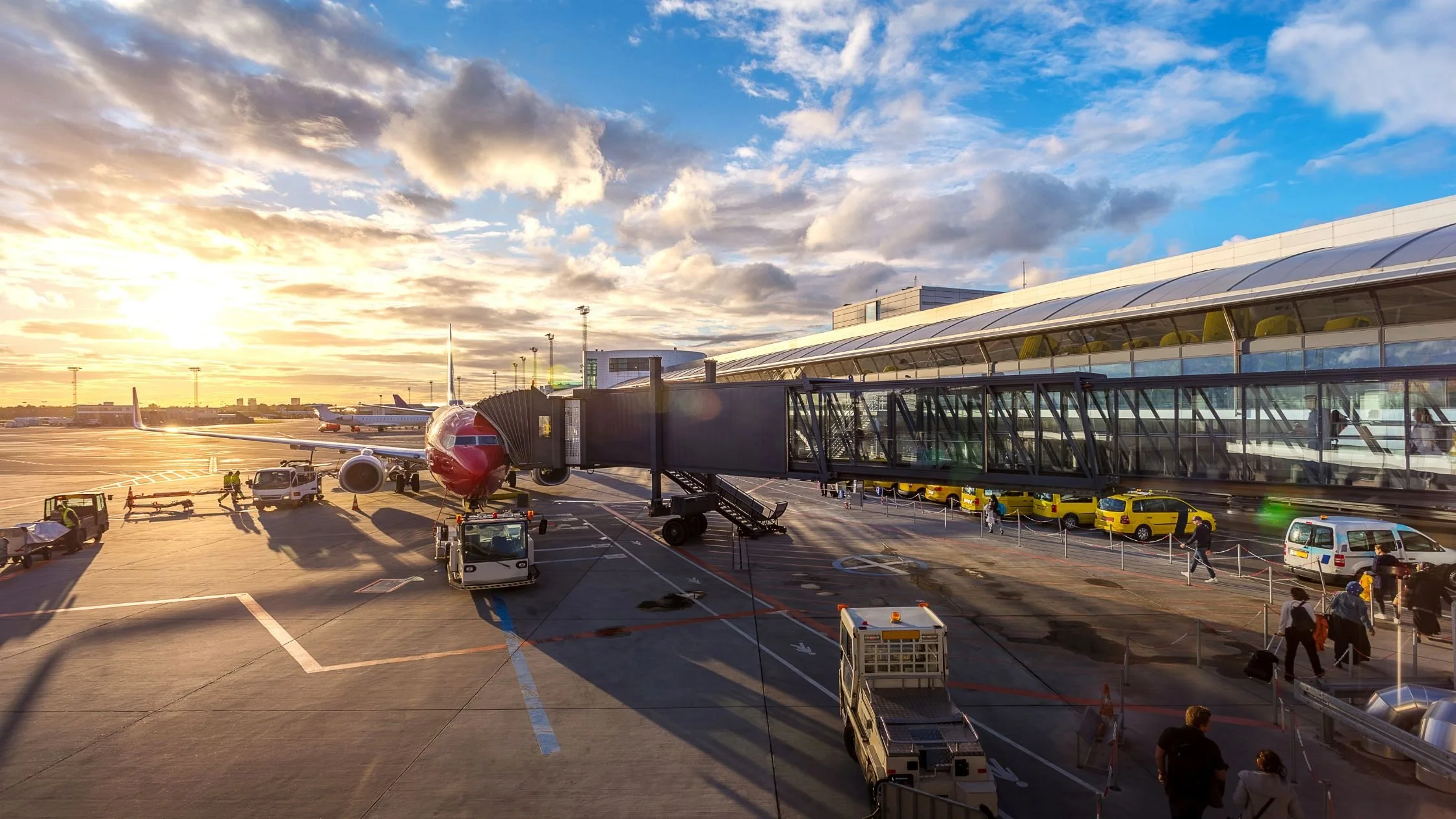 Sunset view at a modern airport terminal with an airplane boarding, symbolising travel and destination weddings in Italy
